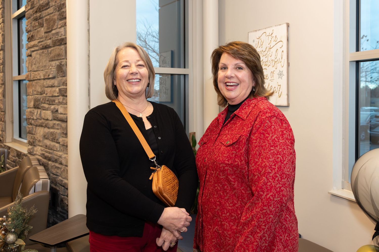 Two women posing together at corporate celebration event.