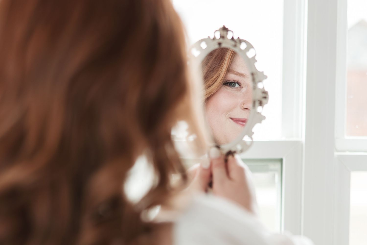 Soft focus reflection image showing bridal details and hair accessories.