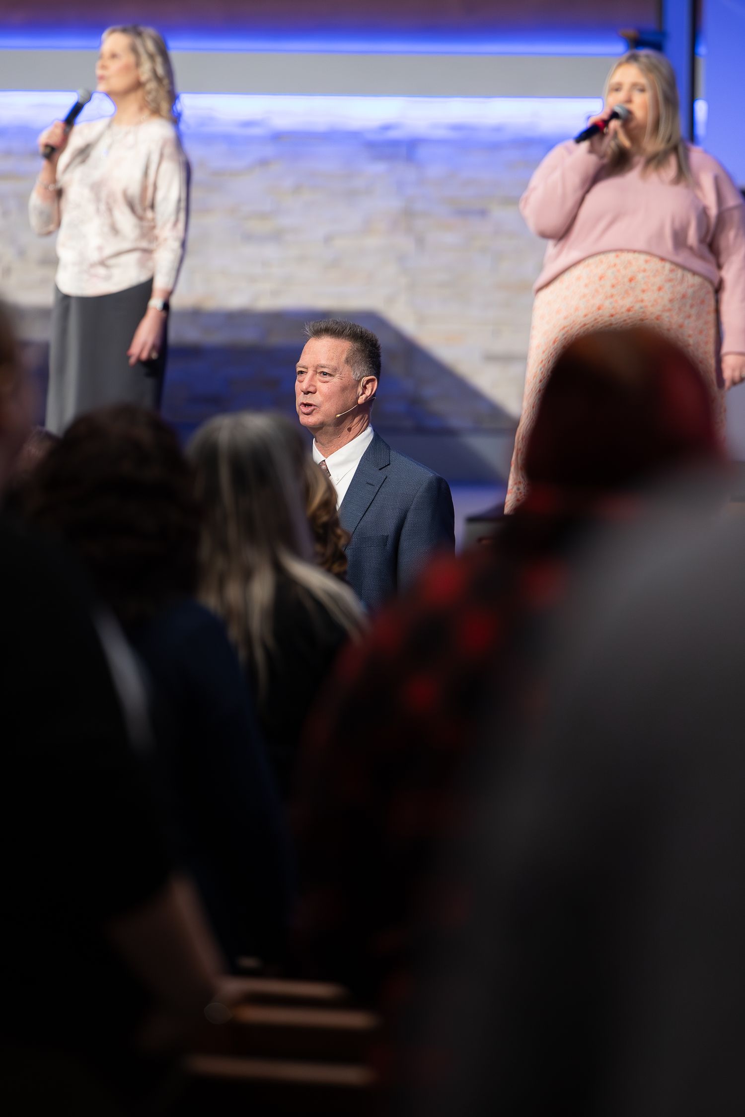 A worship service in progress with singers and musicians performing on stage.