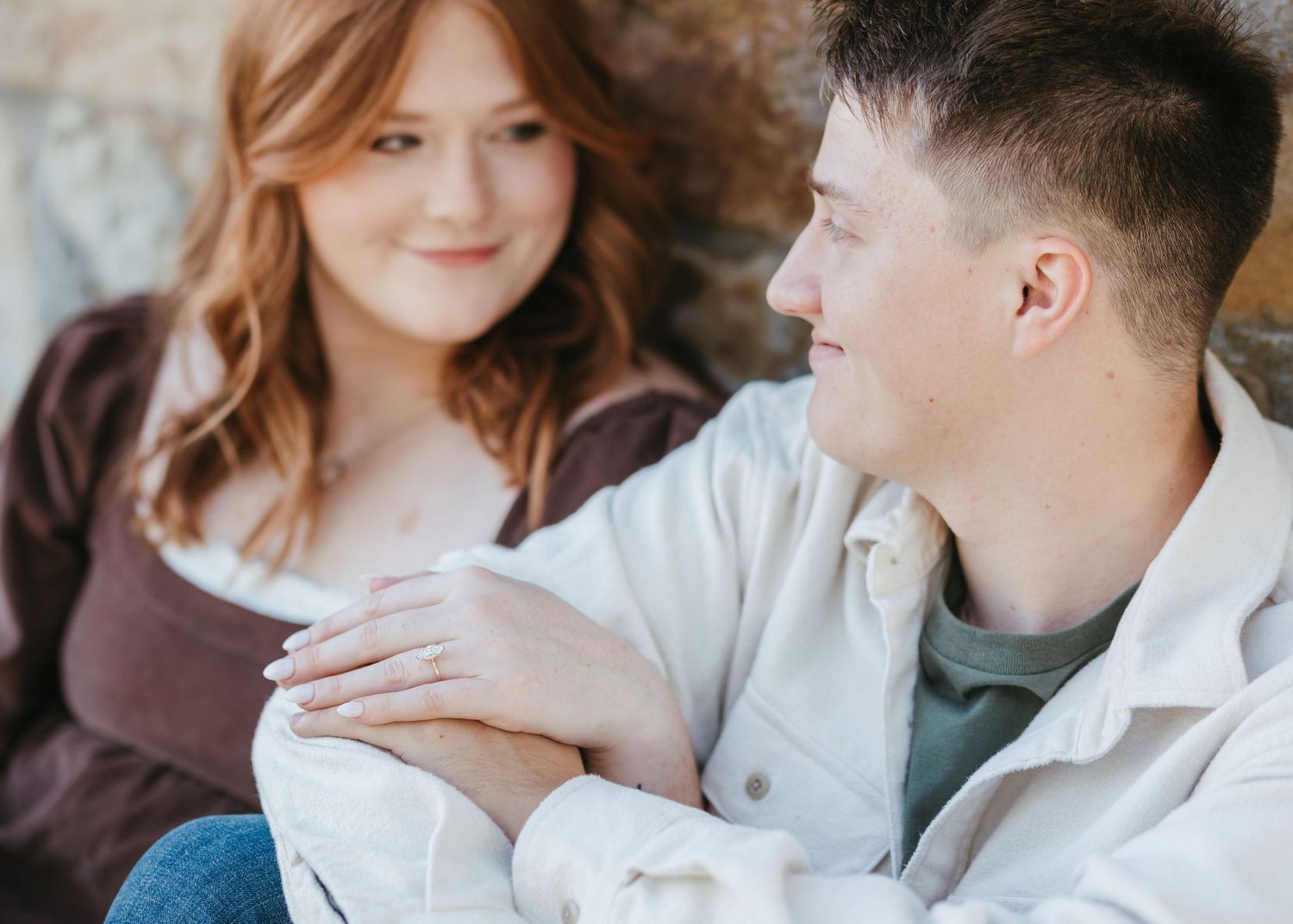 A romantic couple shares an intimate moment while sitting close together.