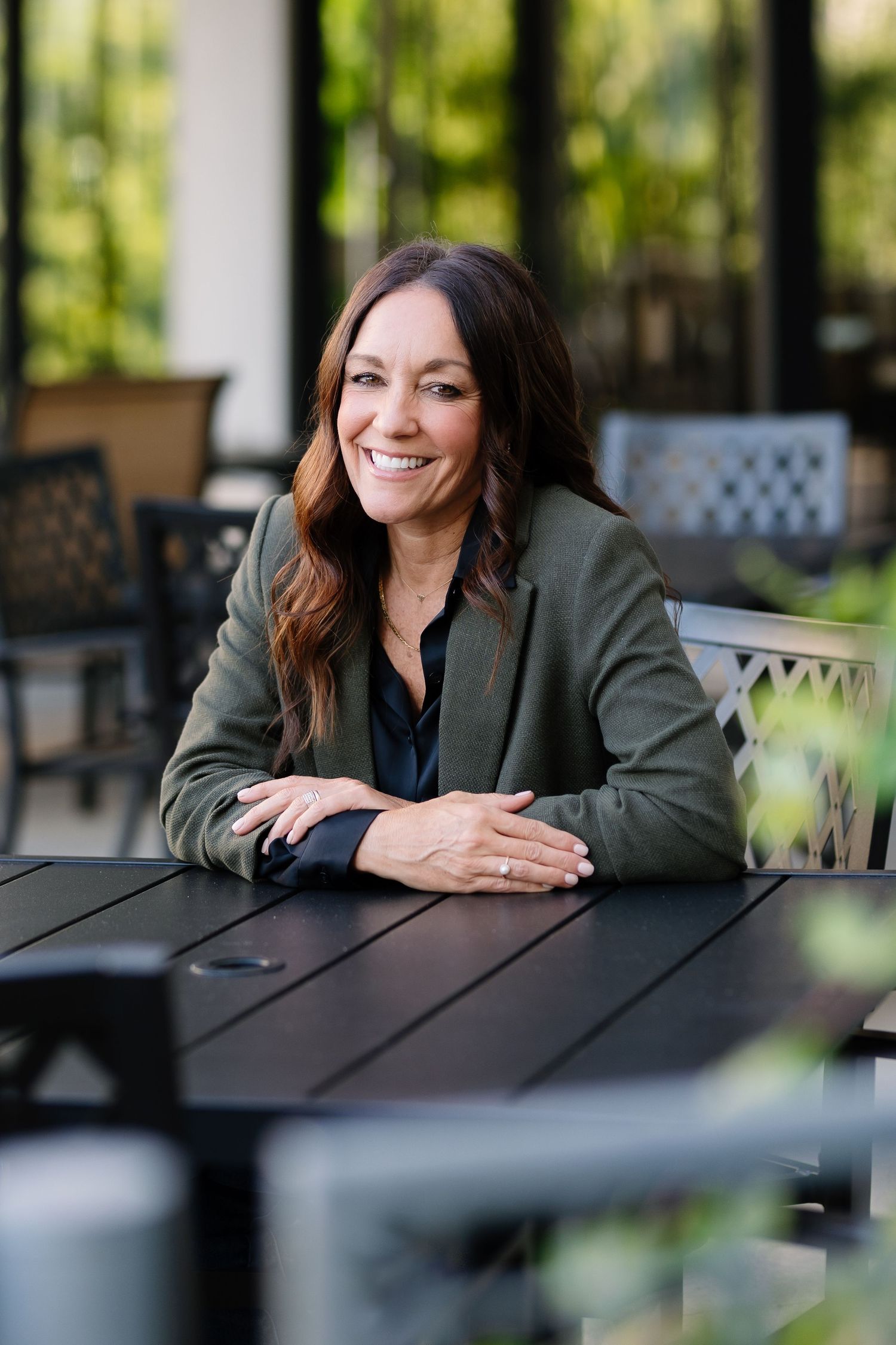 Business casual portrait at outdoor patio table showcasing professional demeanor.