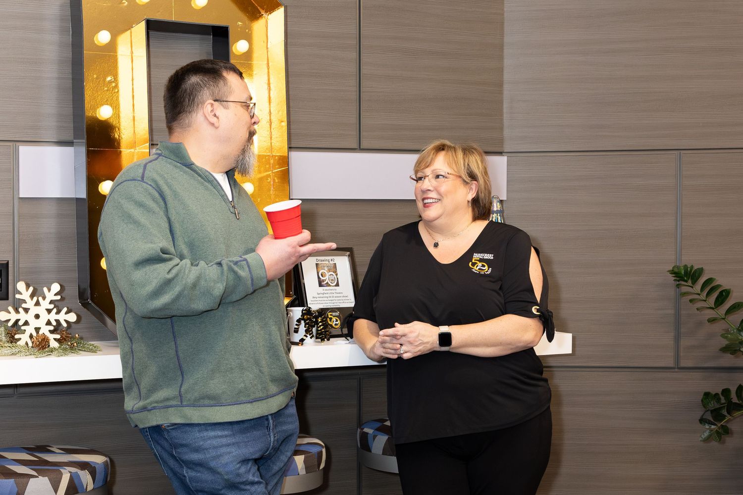 Two people share a lighthearted moment during an indoor celebration.