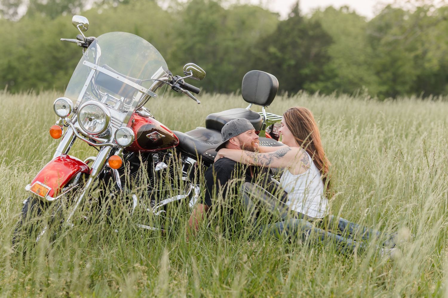 Four images showing a motorcycle lying in a grassy field from different angles and perspectives.