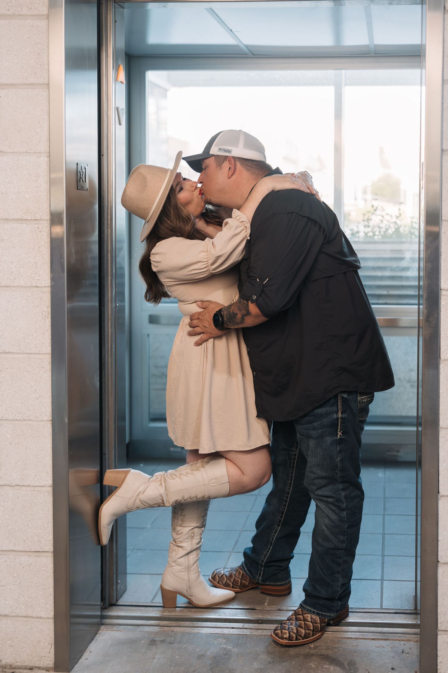 A romantic embrace in an elevator doorway showing affection.