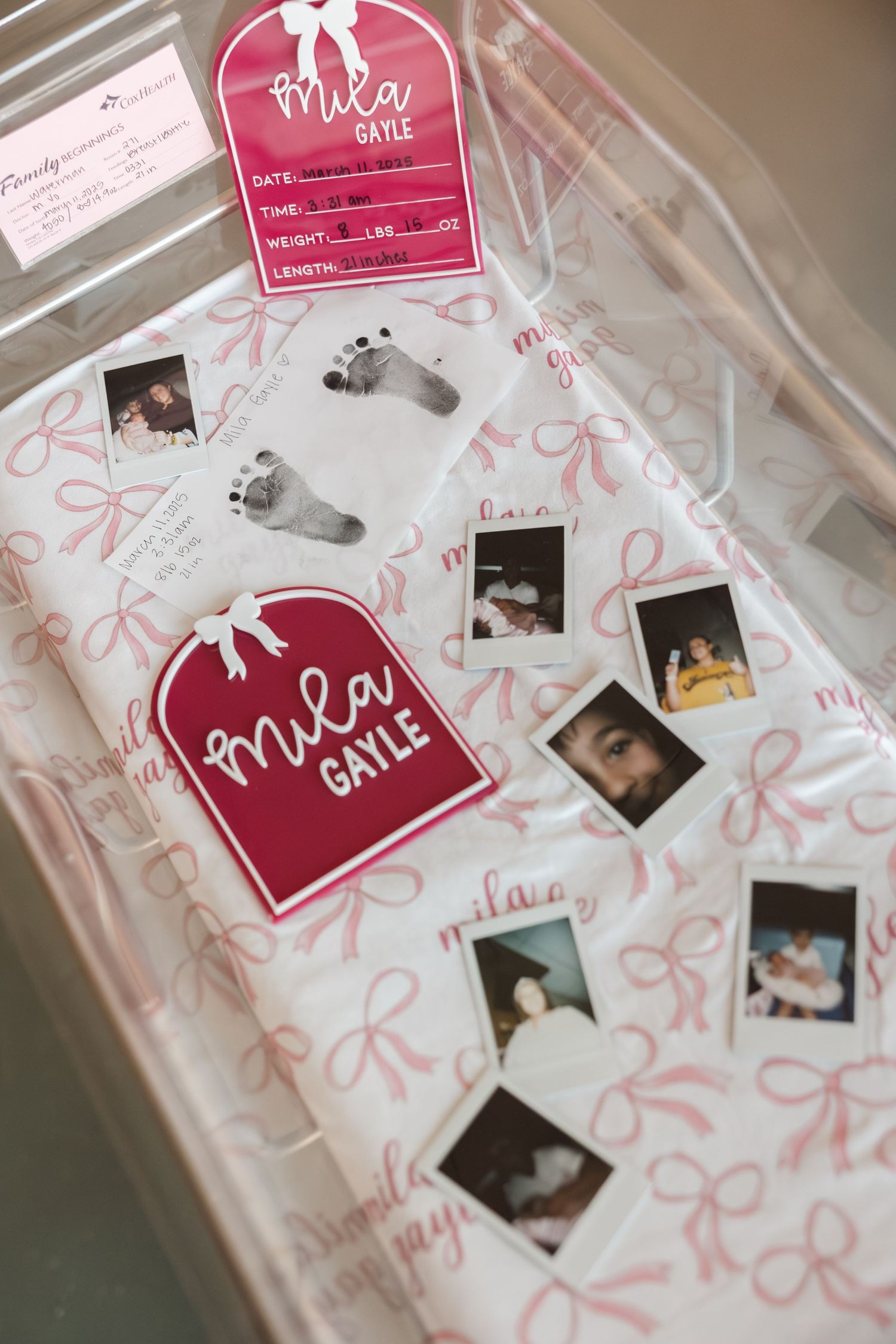 A pink-themed photo album with decorative bows and polaroid pictures displayed on its pages.