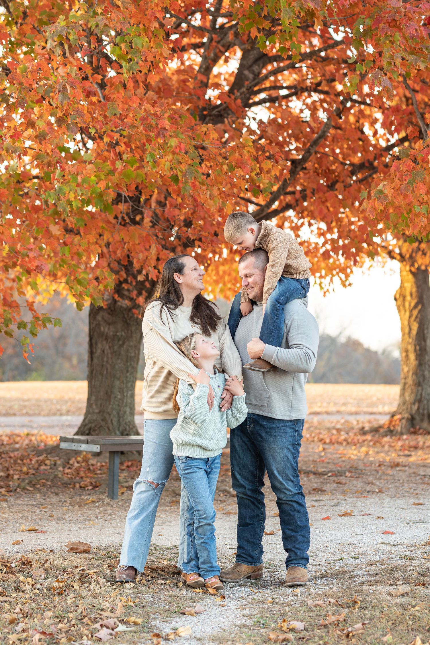 Happy family enjoying a moment together under colorful fall trees.
