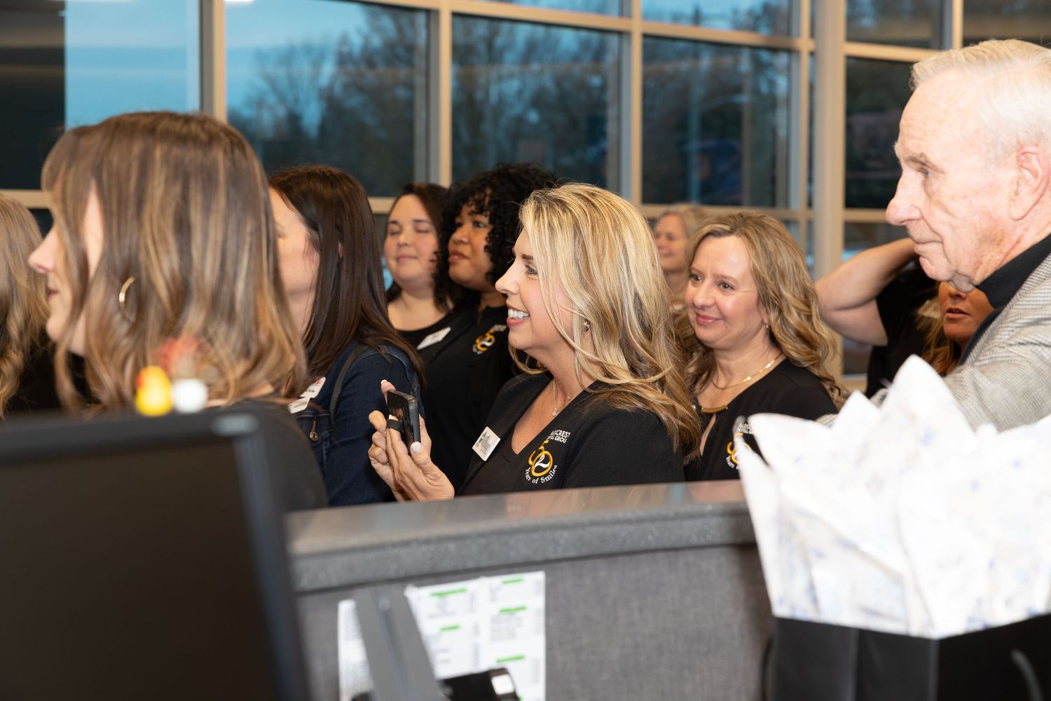 Group of employees engaging in conversation at an office reception area.