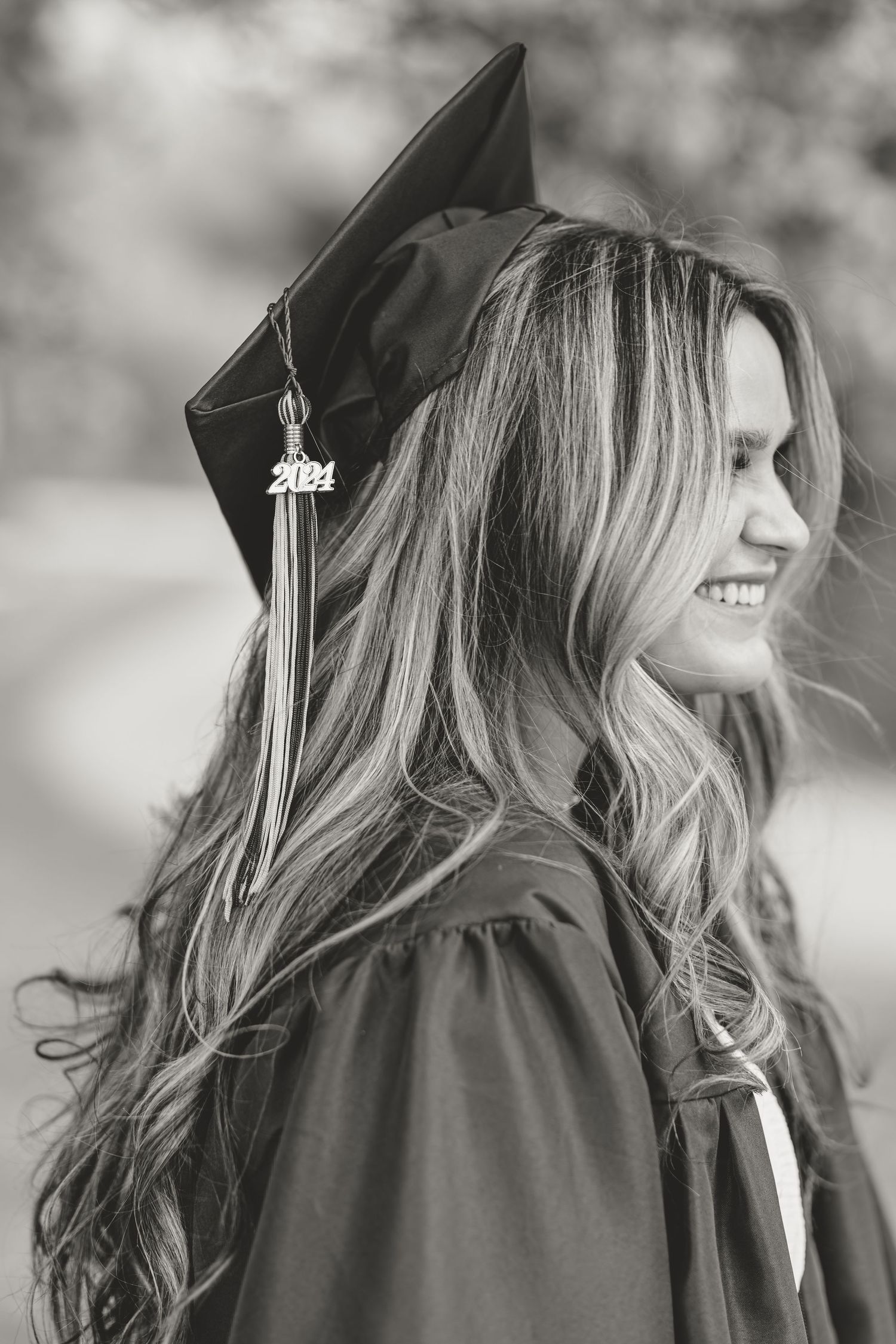 Black and white graduation photo showing cap and flowing hair in profile view.