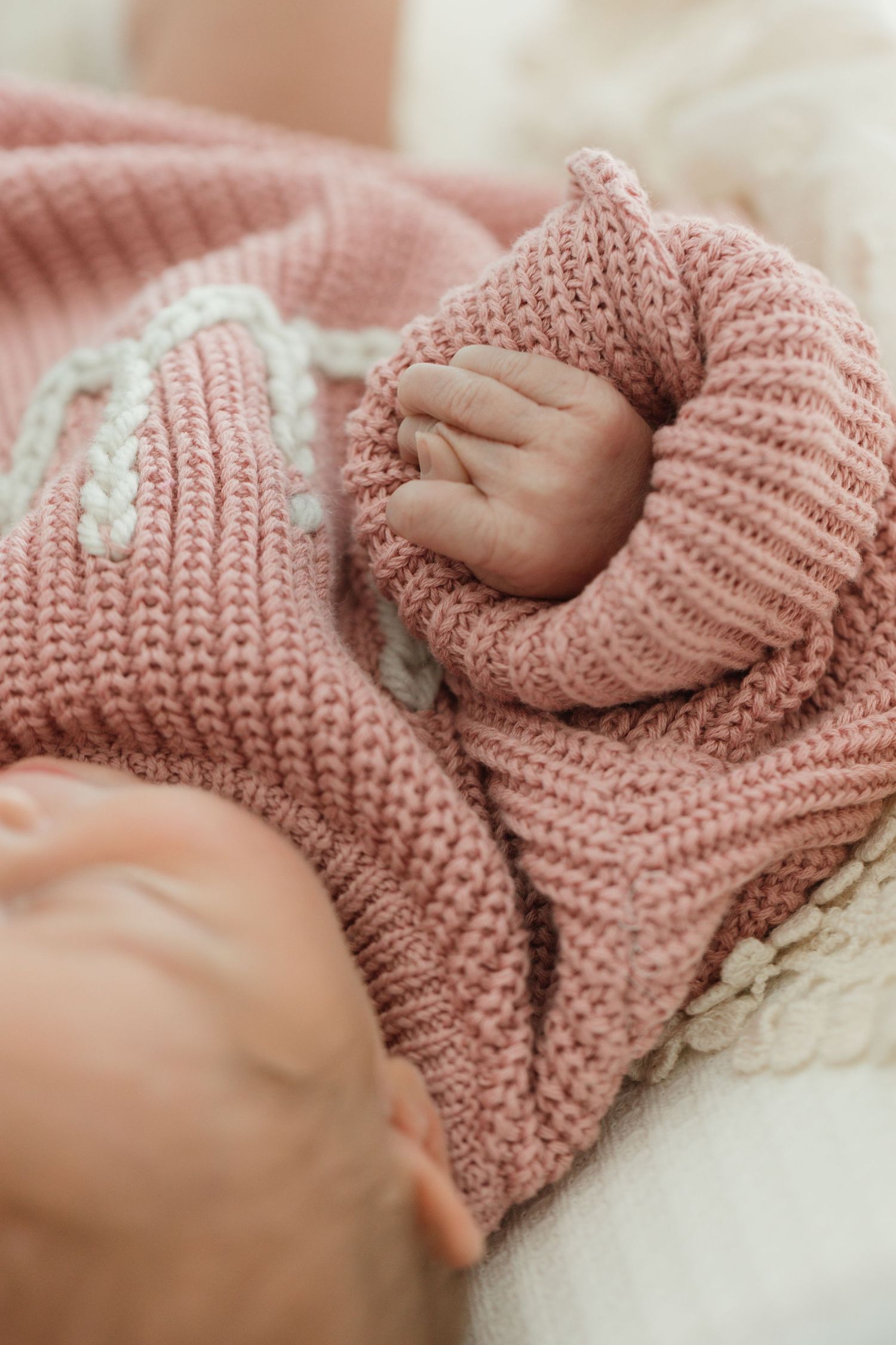 Close-up photo series showing small hands grasping pink knitted fabric in soft, gentle poses.