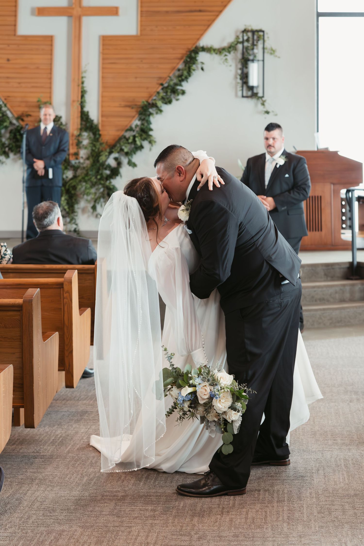 Newlyweds share their first kiss as husband and wife during church ceremony.