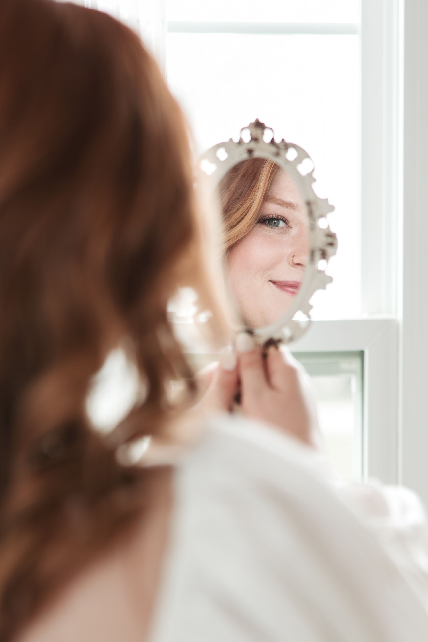 Pearl-adorned wedding accessory reflected in elegant mirror.