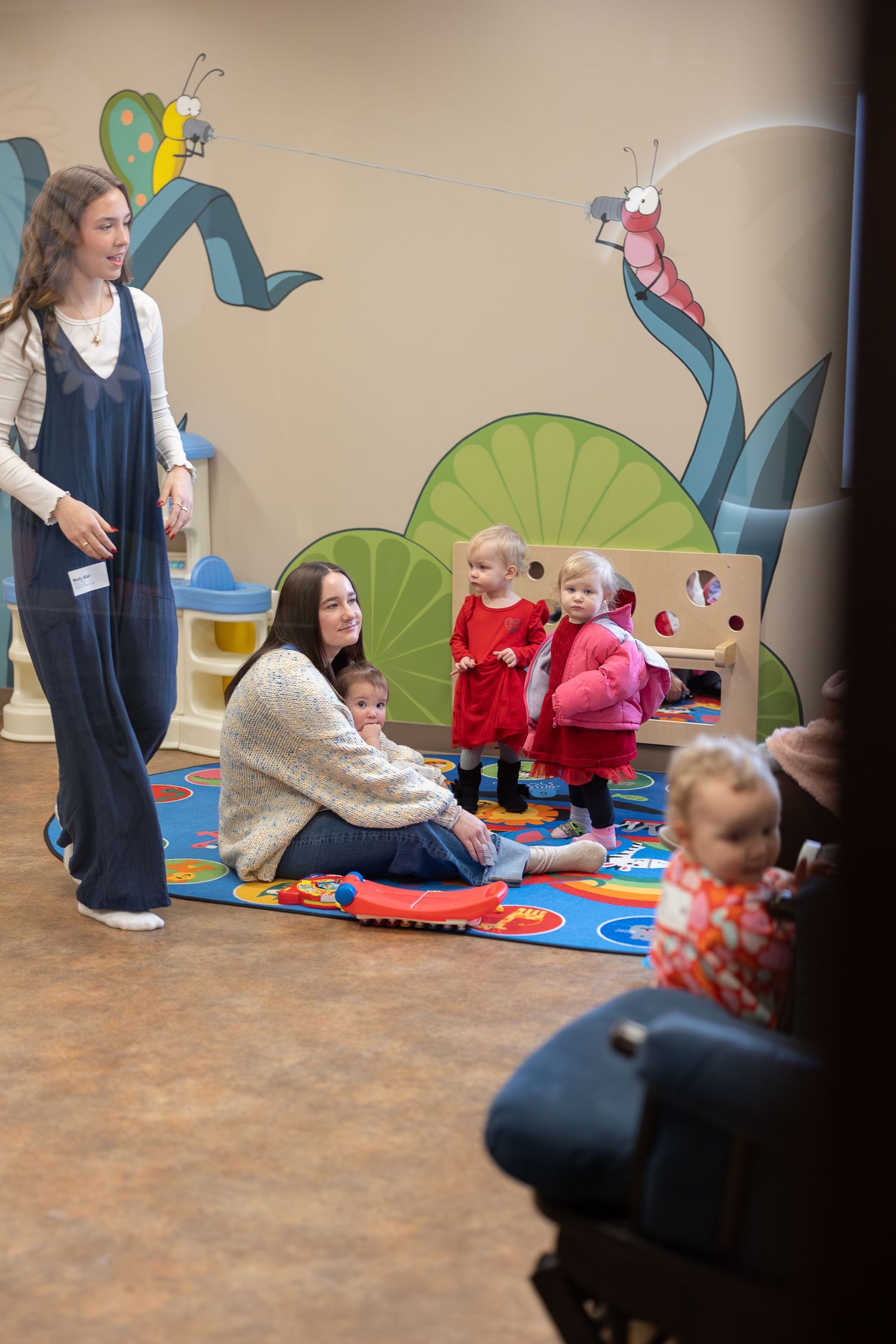 Early childhood classroom with nature-themed wall murals and interactive learning activities.