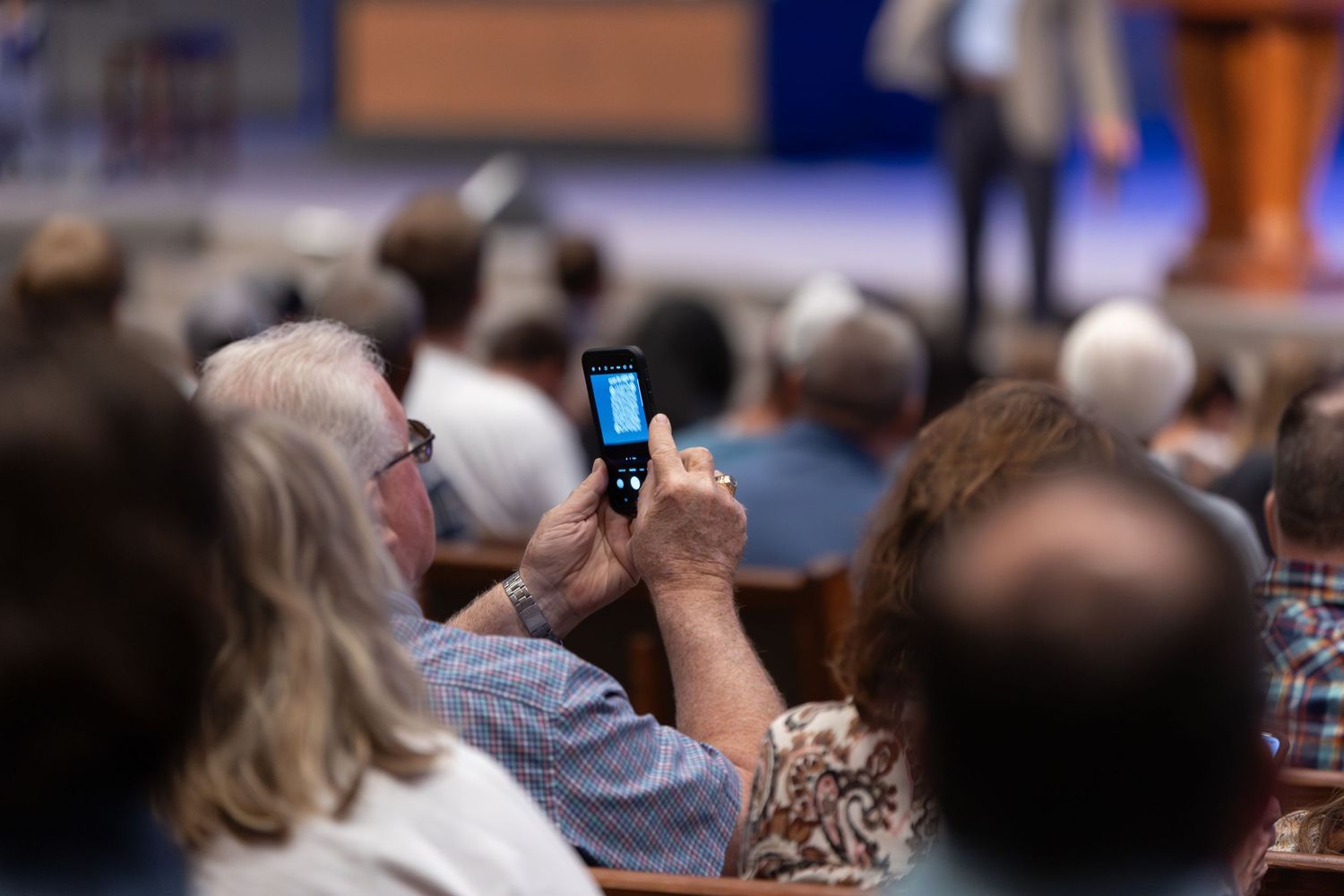An audience member captures a photo during a church service.