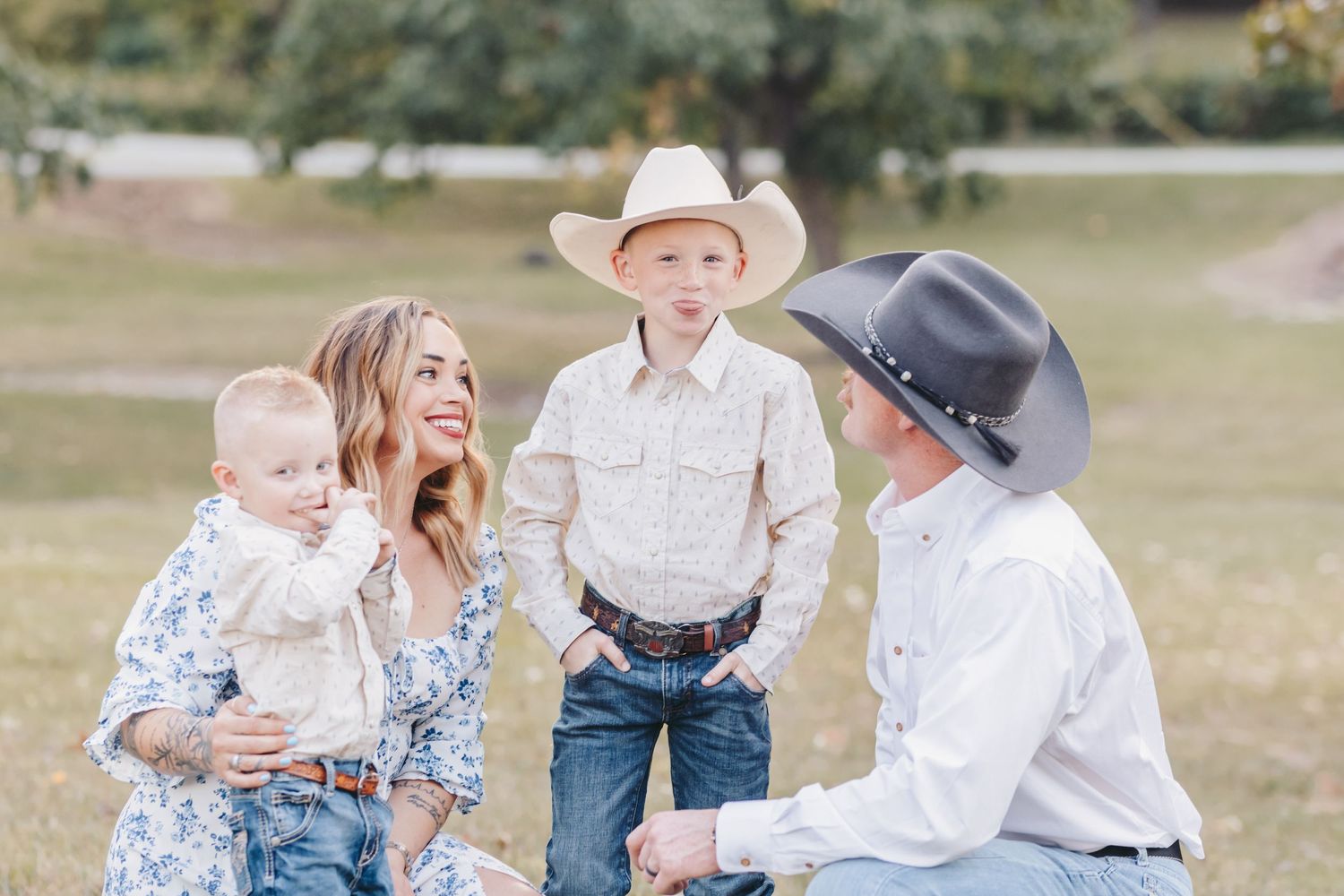 A casual family gathering photographed in a sun-dappled park setting.