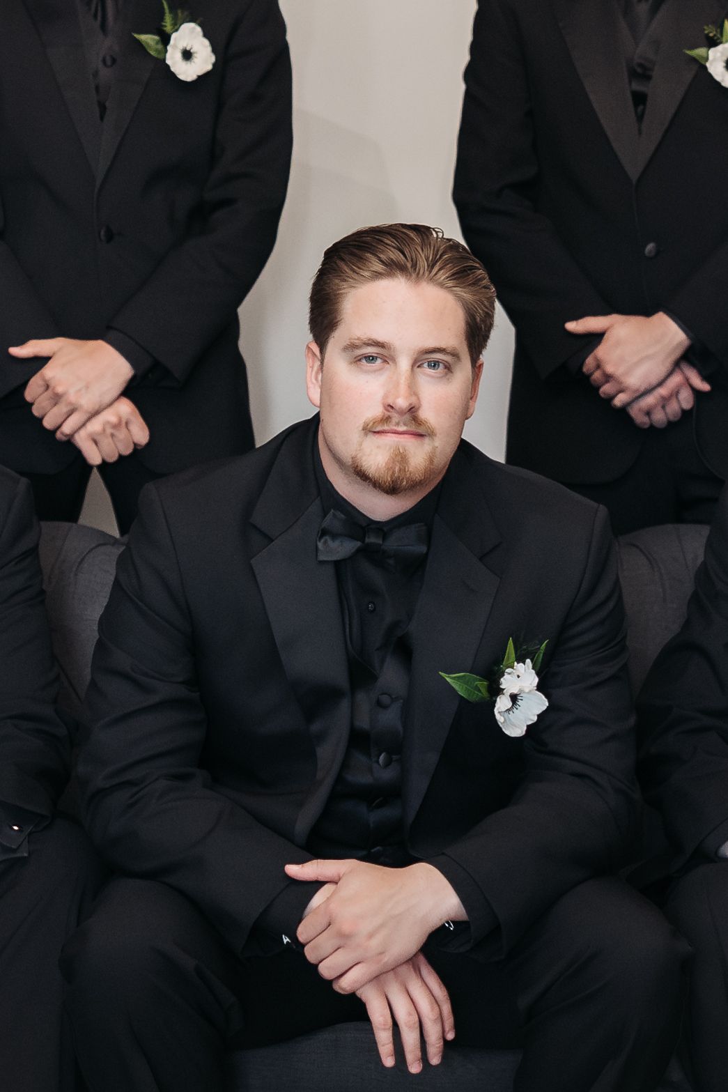 Classic black tuxedo with white boutonniere for formal wedding attire.