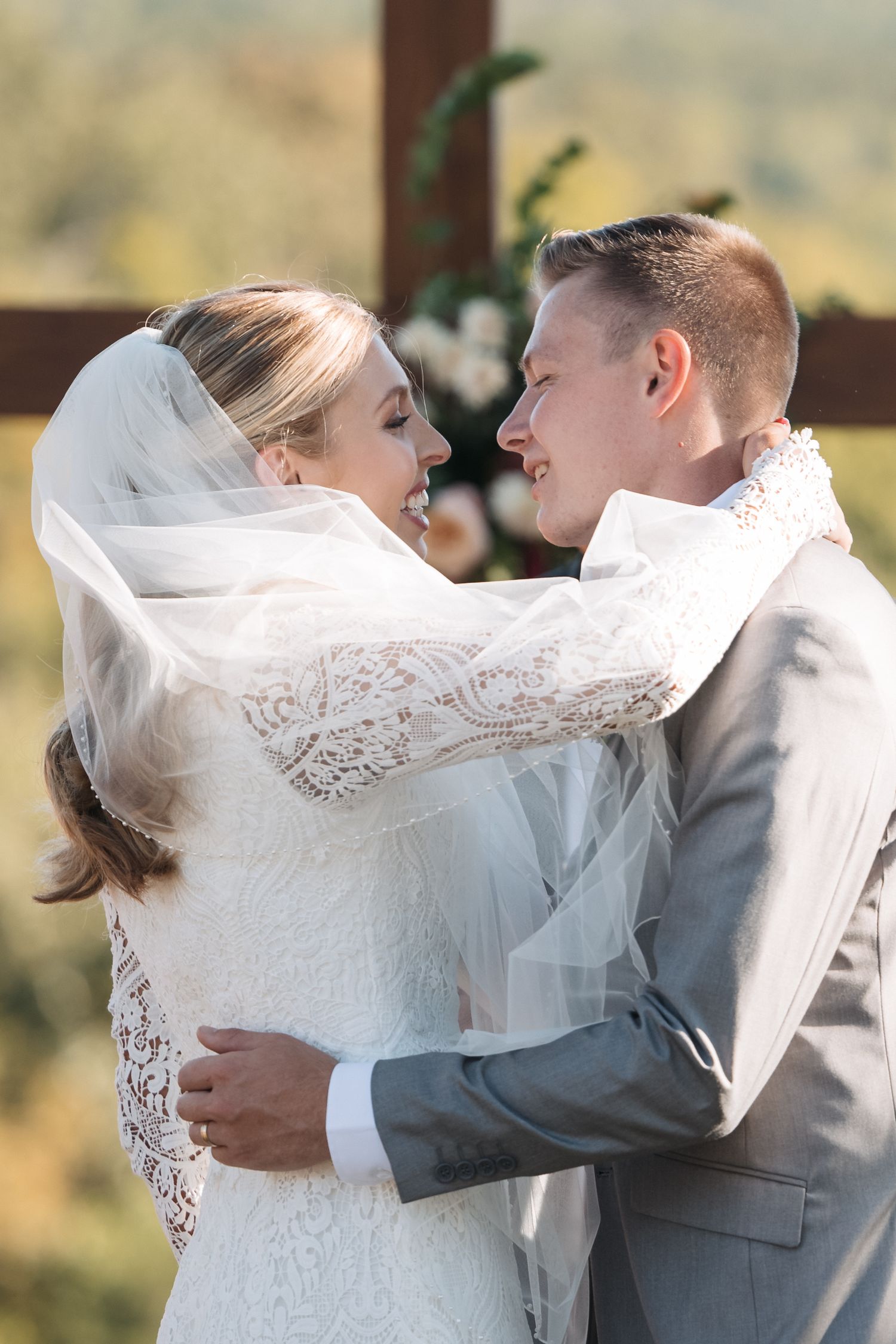 A tender moment between newlyweds as they embrace during their outdoor ceremony.