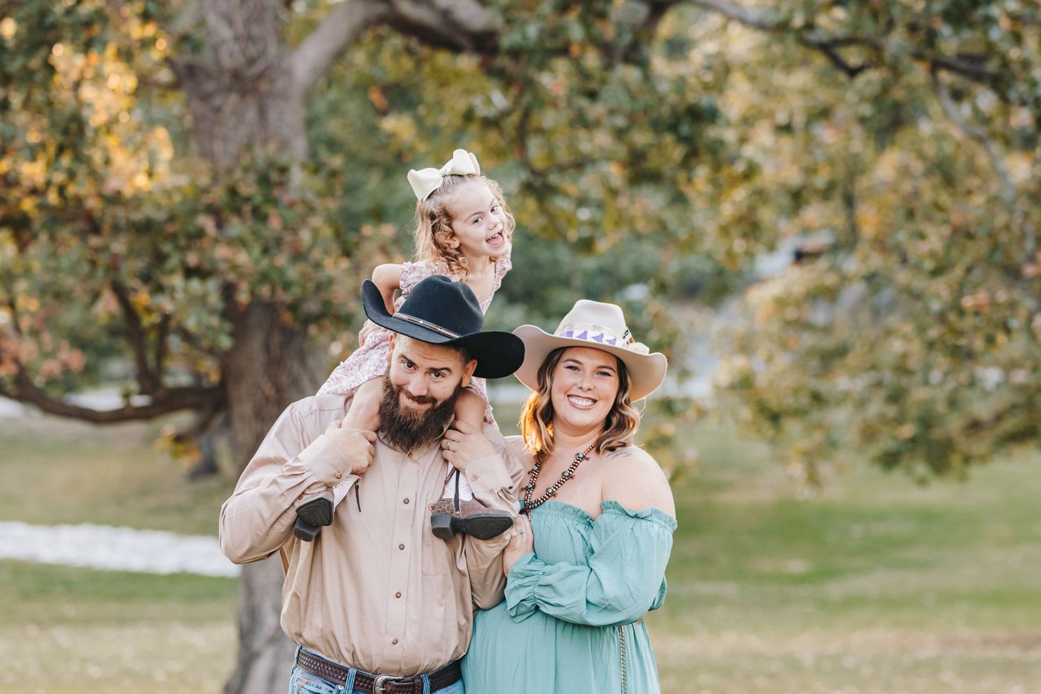 A candid outdoor family portrait captured in a golden-lit park setting.