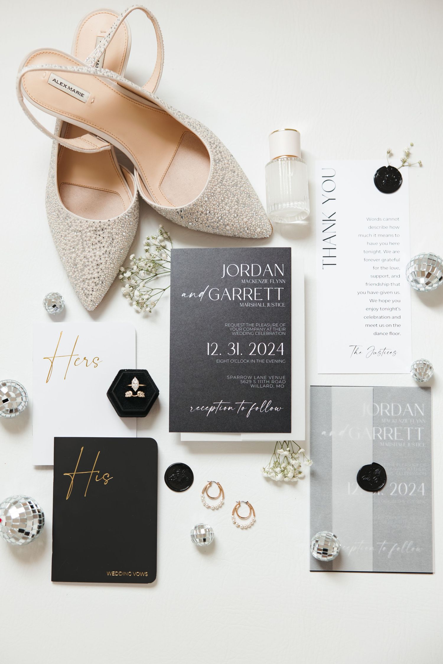 Wedding invitation suite with sparkly shoes, rings, and silver ornaments on white background.