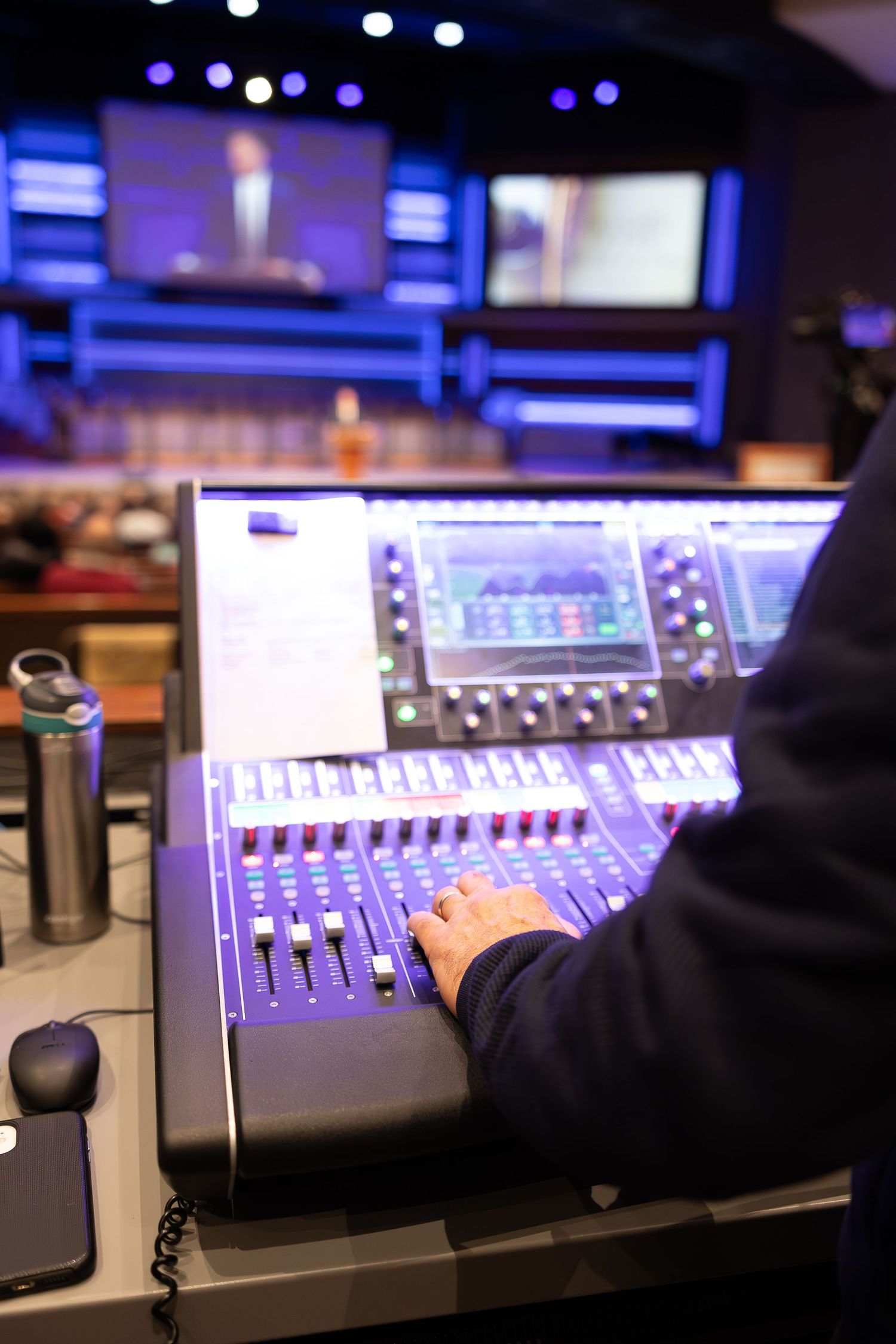 Close-up of digital audio mixing console with professional controls and displays.