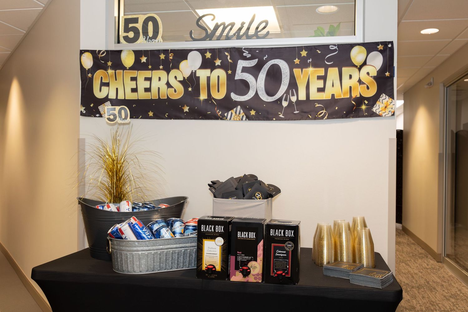 Black table display with 50th anniversary banner and refreshments setup.