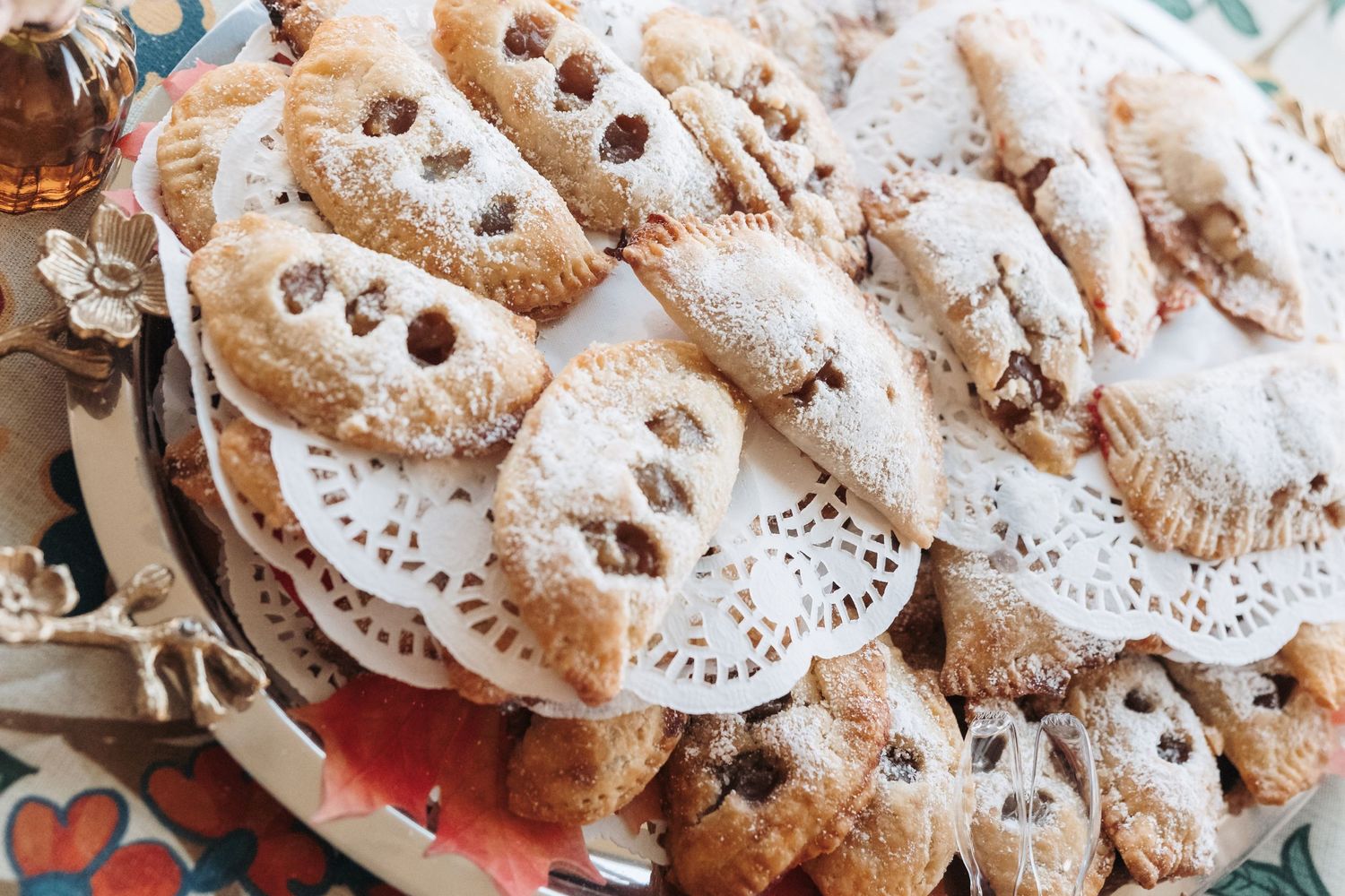Powdered sugar-dusted Italian wedding cookies arranged on a decorative doily.