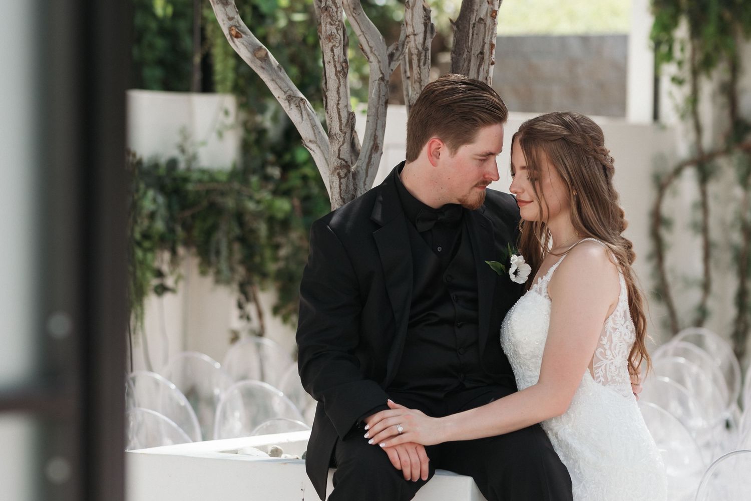 Romantic wedding moment captured in an elegant white indoor venue.
