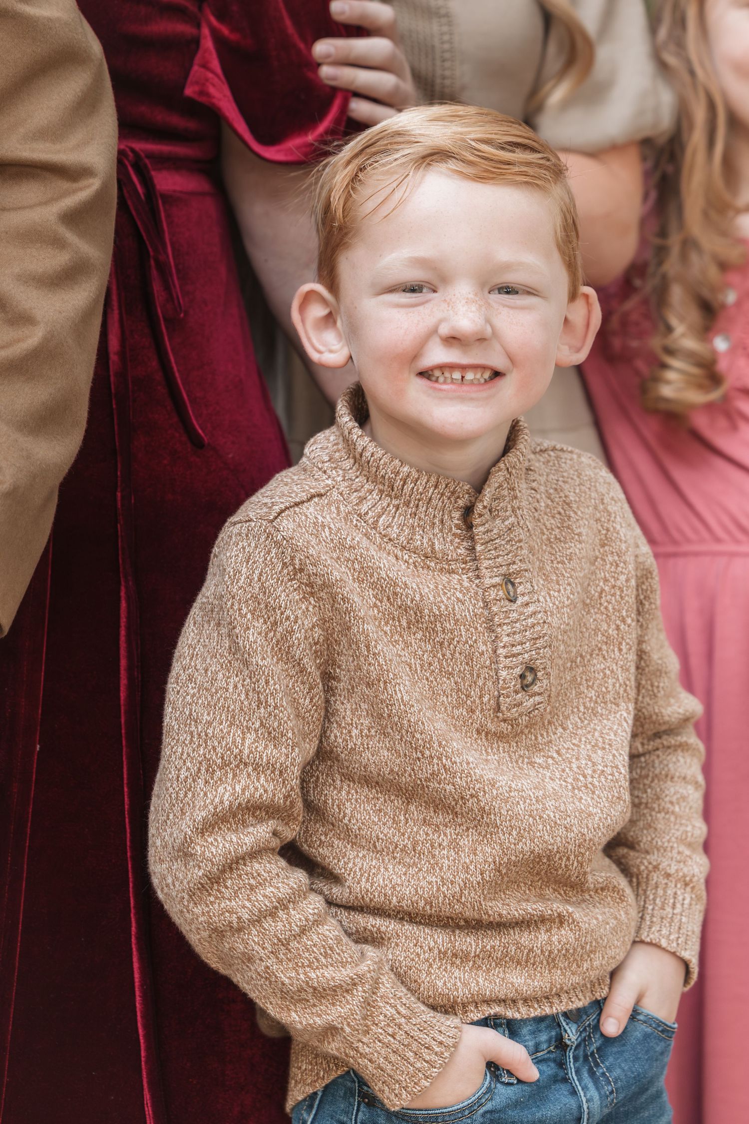 Portrait wearing cozy tan sweater against burgundy and neutral tones.