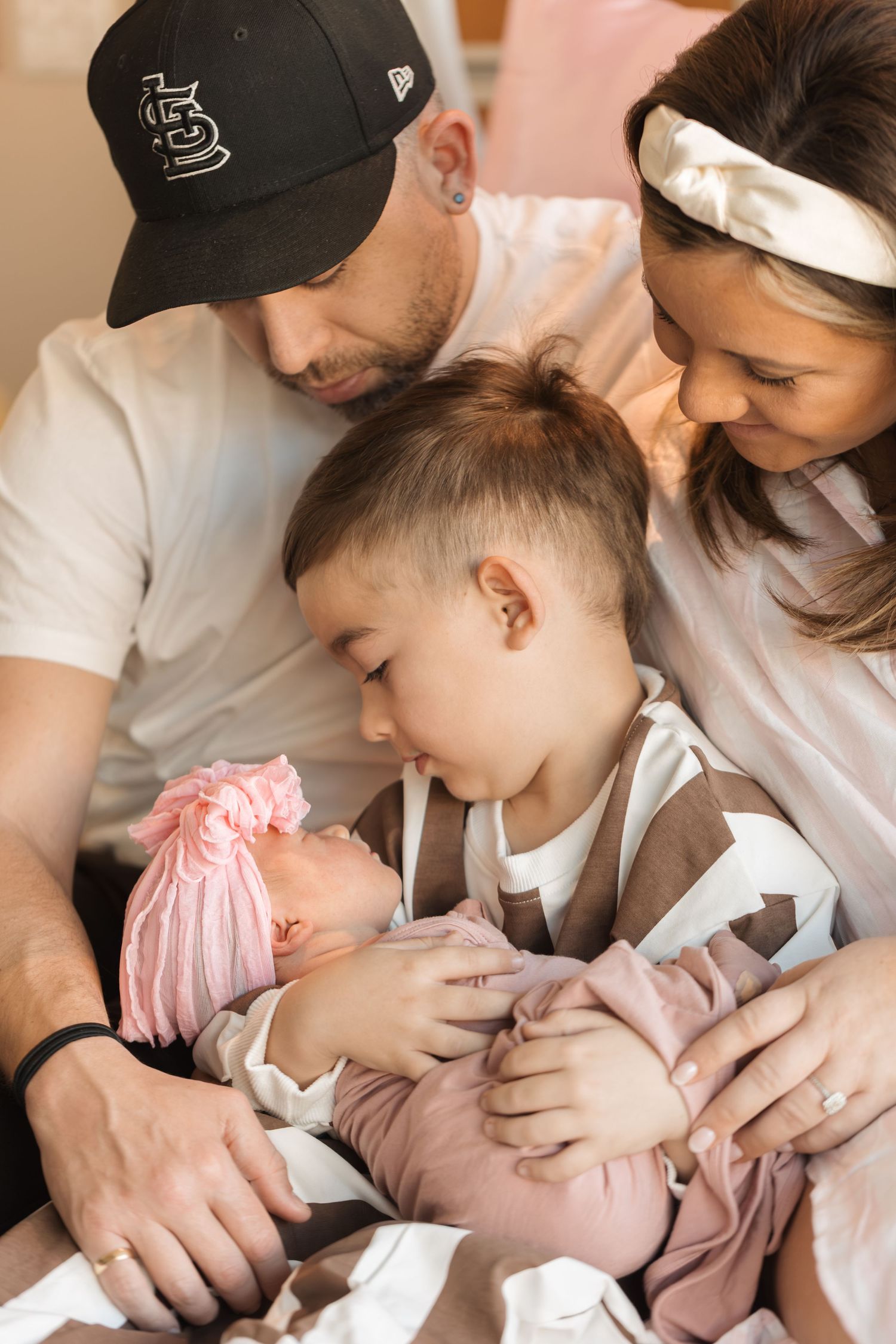 A newborn sleeps peacefully in a series of connected photos showing tender care and affection from caregivers.