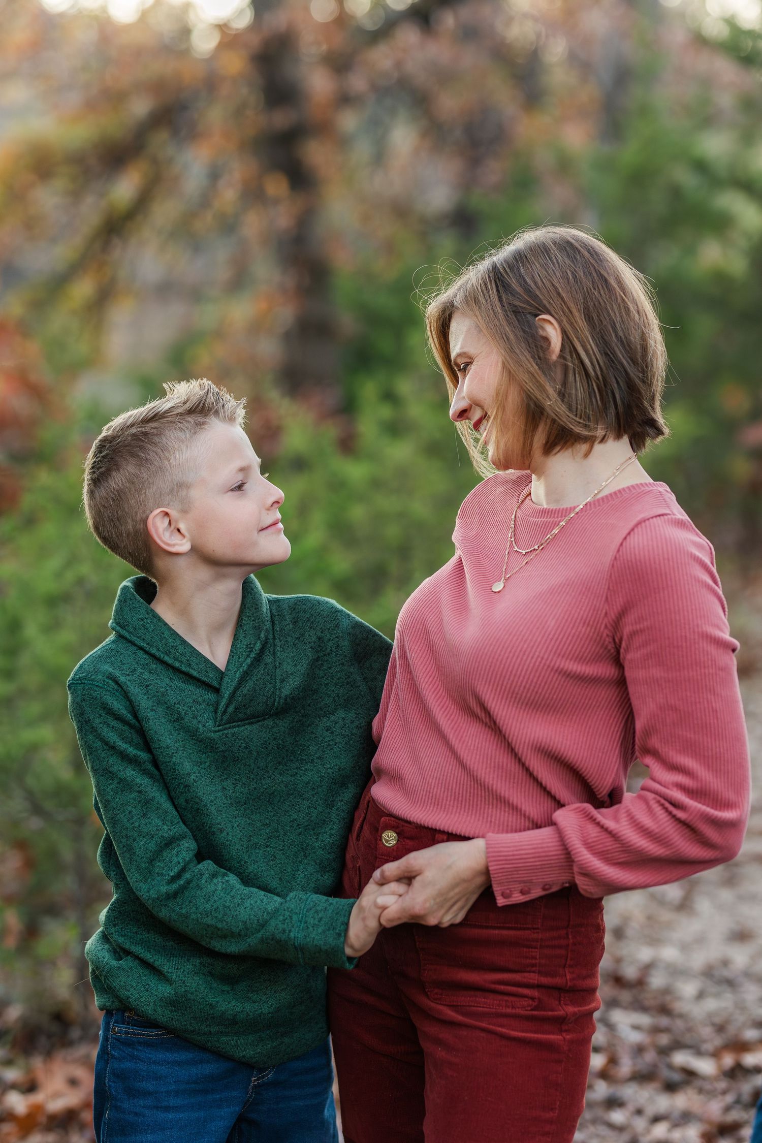 Mother and child in coordinated sweaters sharing tender moment outdoors.