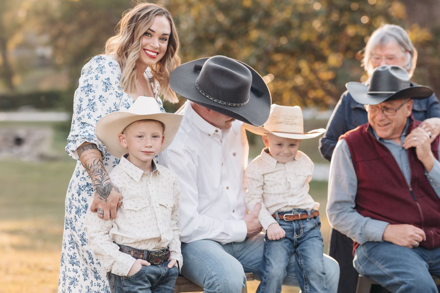 A western-themed family photo session in a park during golden hour.