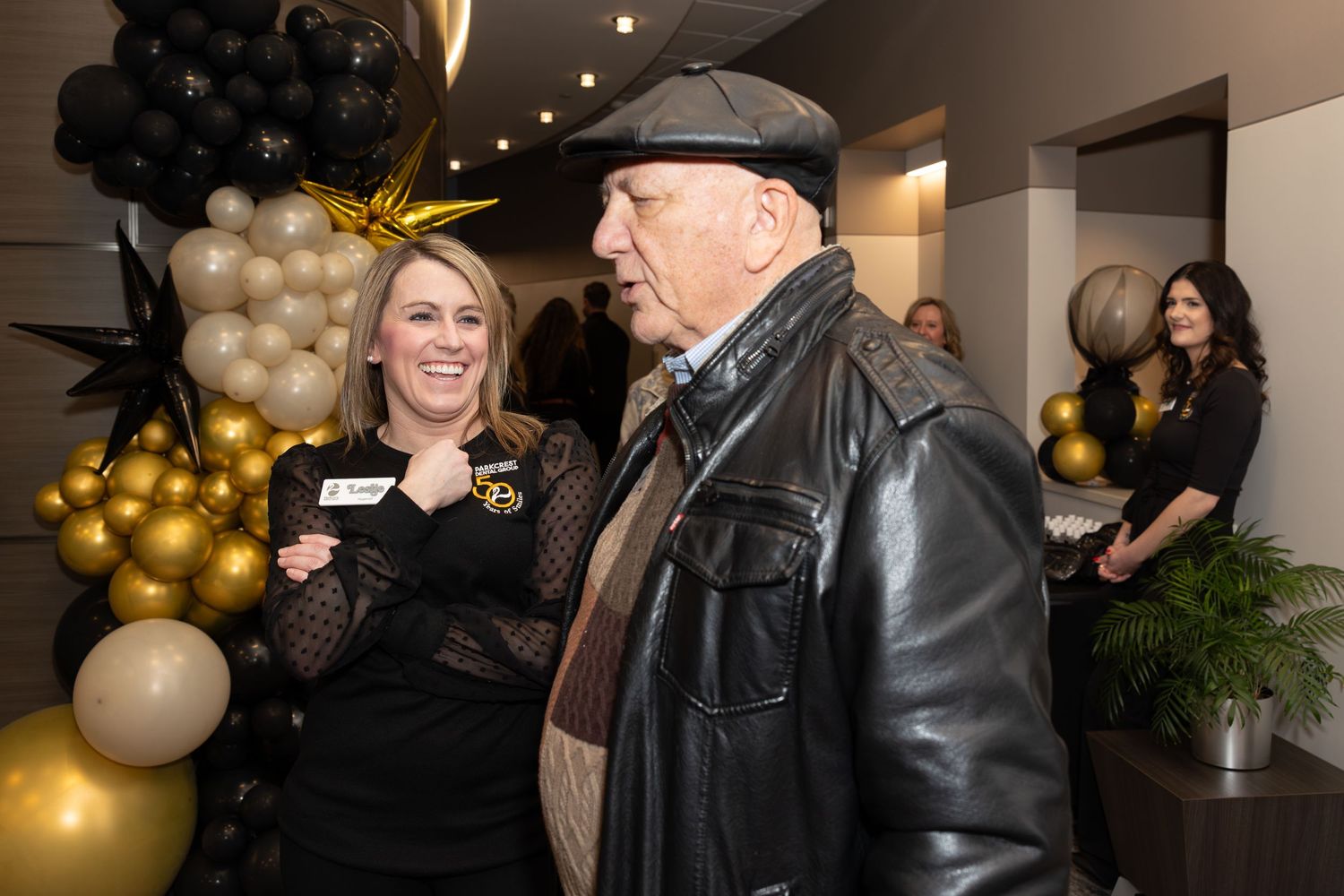 Event guests chatting near decorative balloon arrangement.
