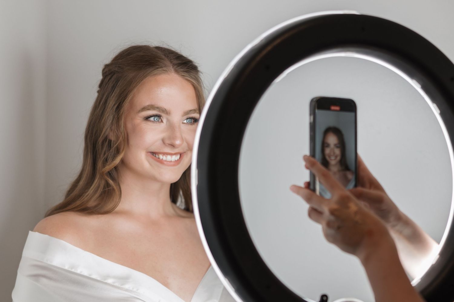 Ethereal bridal preparation scene with ring light reflection.