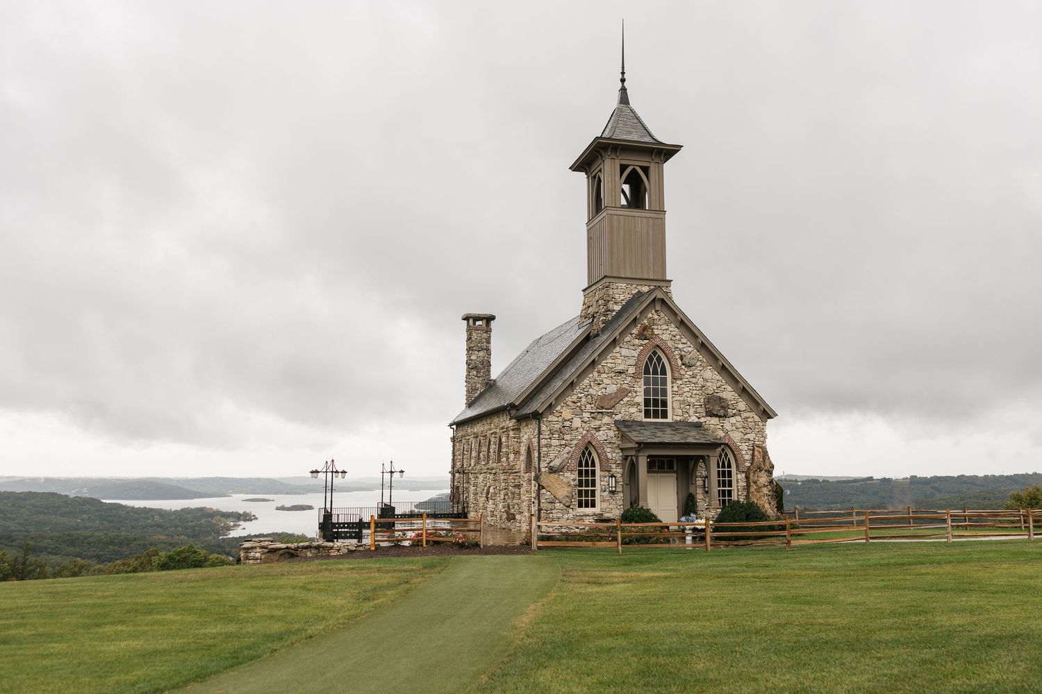 Historic wooden church stands isolated on a grassy hilltop under moody cloudy skies in rural Montana.
