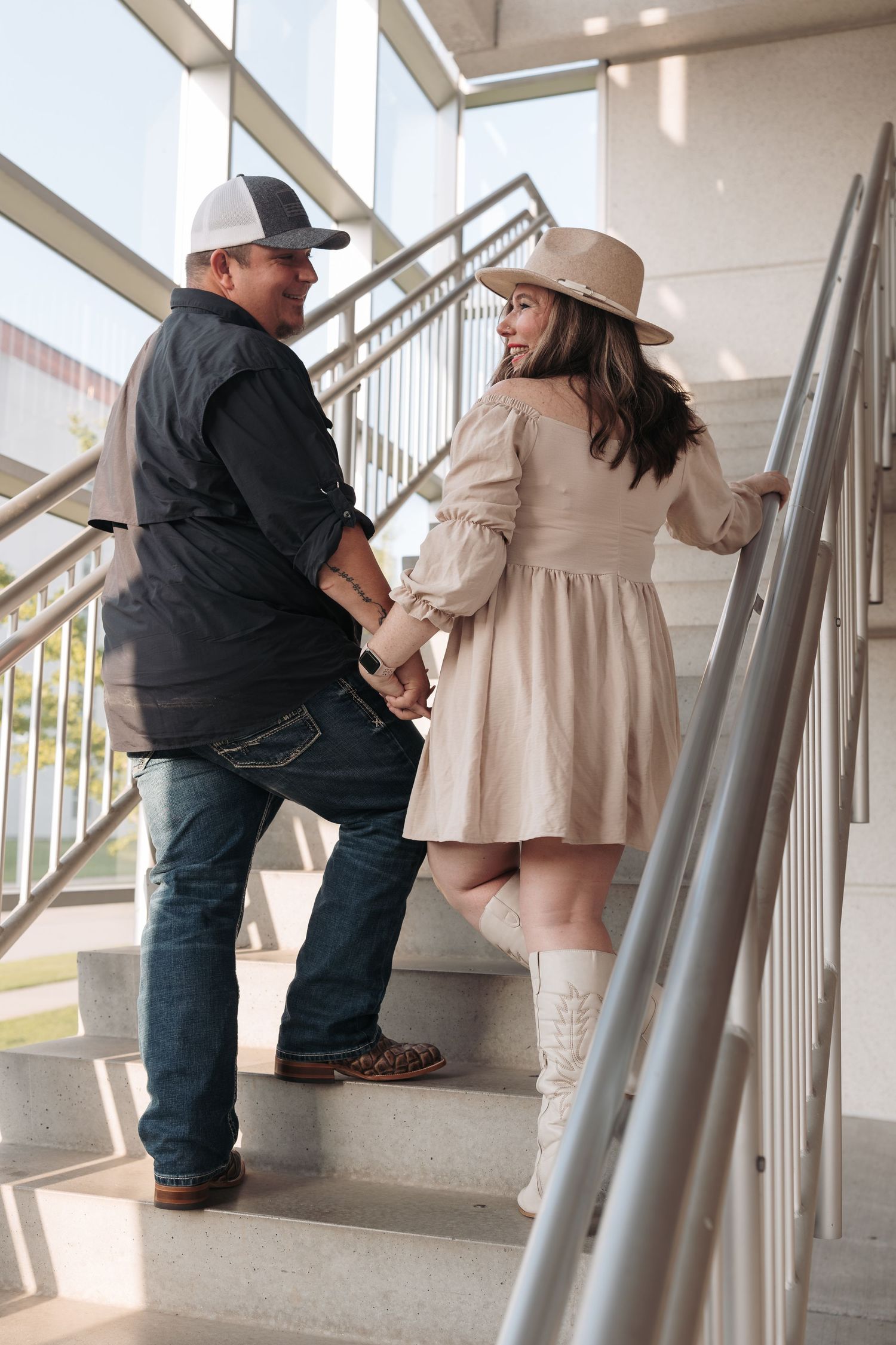 A couple in casual attire sharing a moment on concrete stairs.