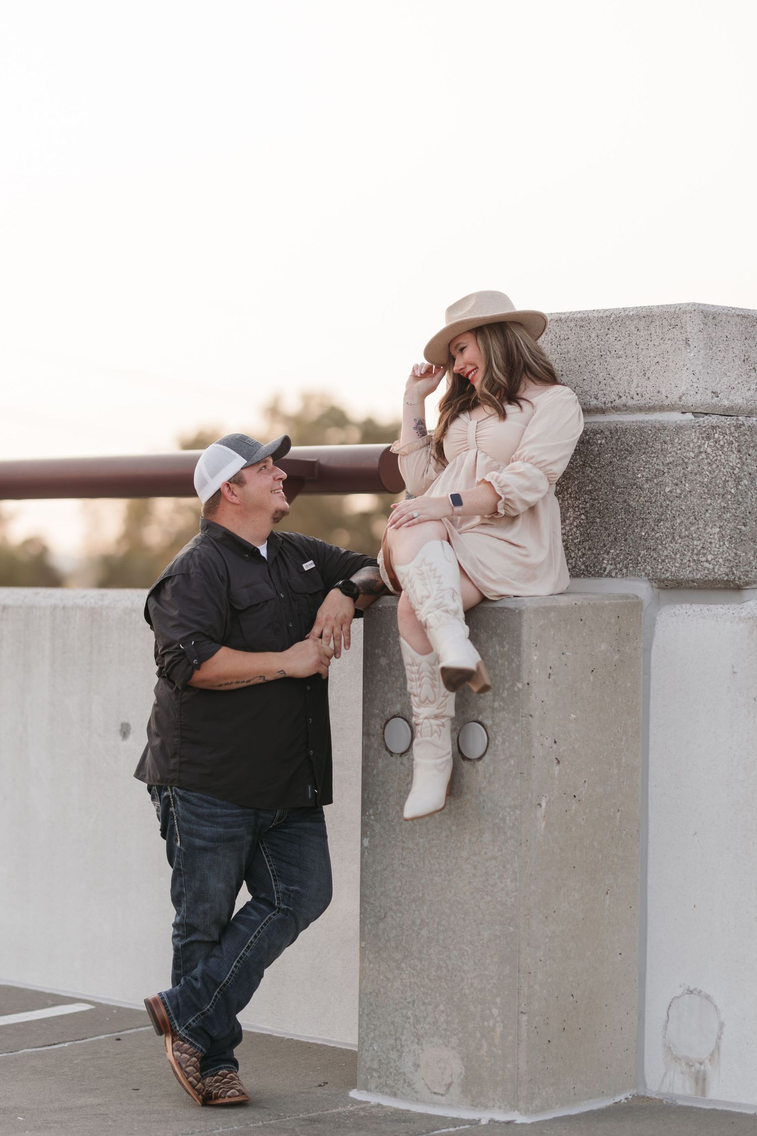 A proposal scene on a concrete ledge during golden hour.