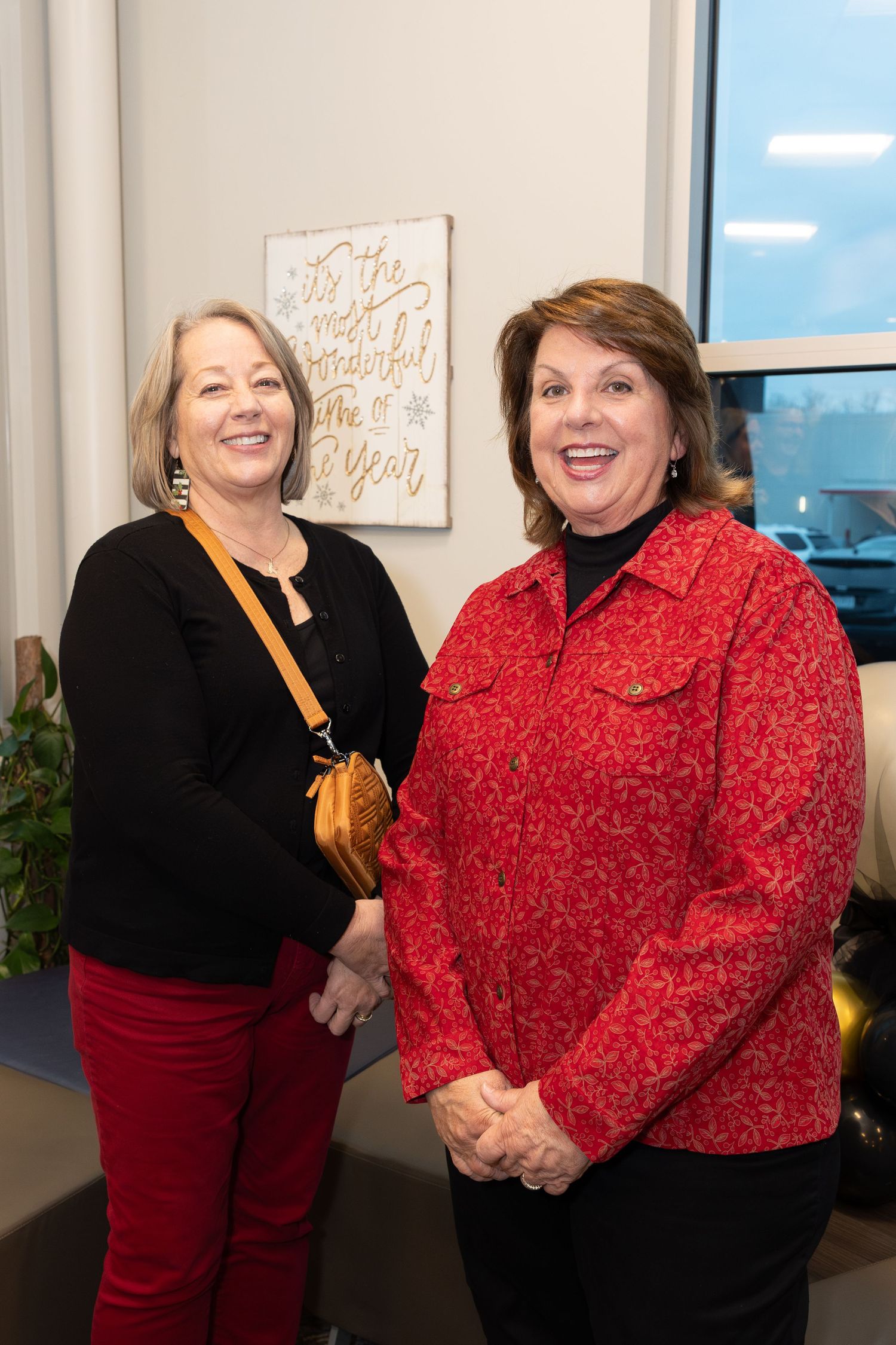 Two women smiling and celebrating at a corporate event.