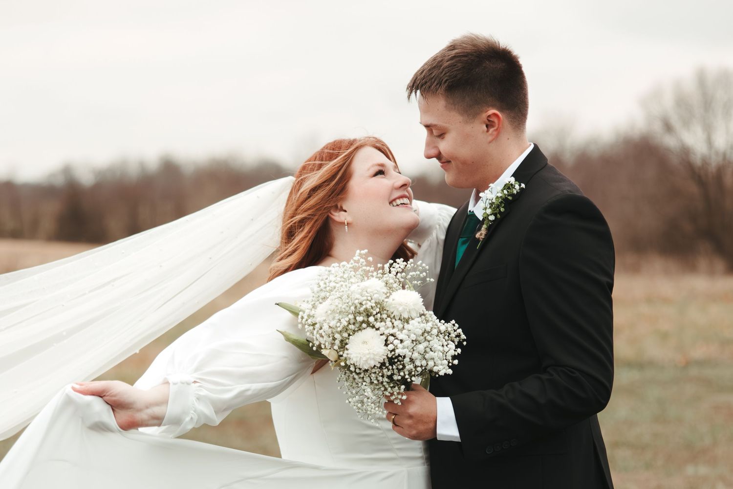 Romantic wedding portrait with flowing veil and white baby's breath bouquet.
