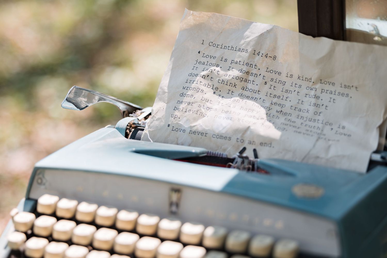 Vintage blue typewriter with paper containing wedding vows or love letter.