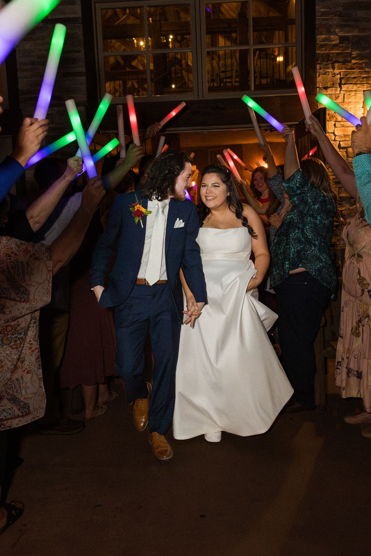 Wedding reception dance floor scene with colorful LED light wands glowing in the dark.