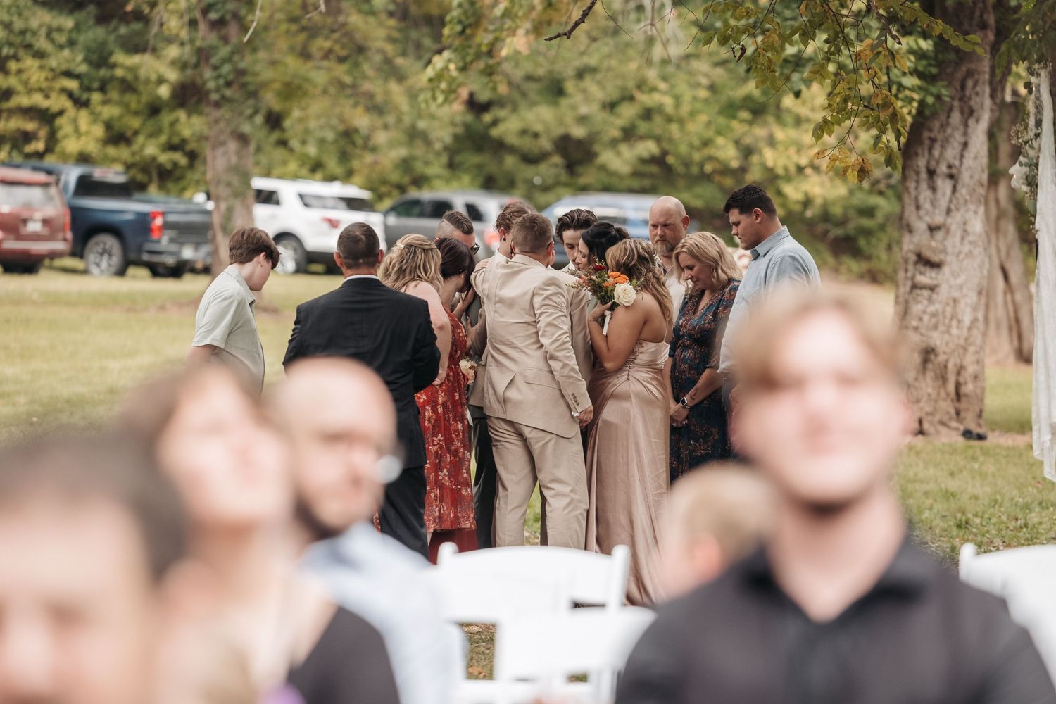 Outdoor wedding ceremony gathering with guests in casual attire.