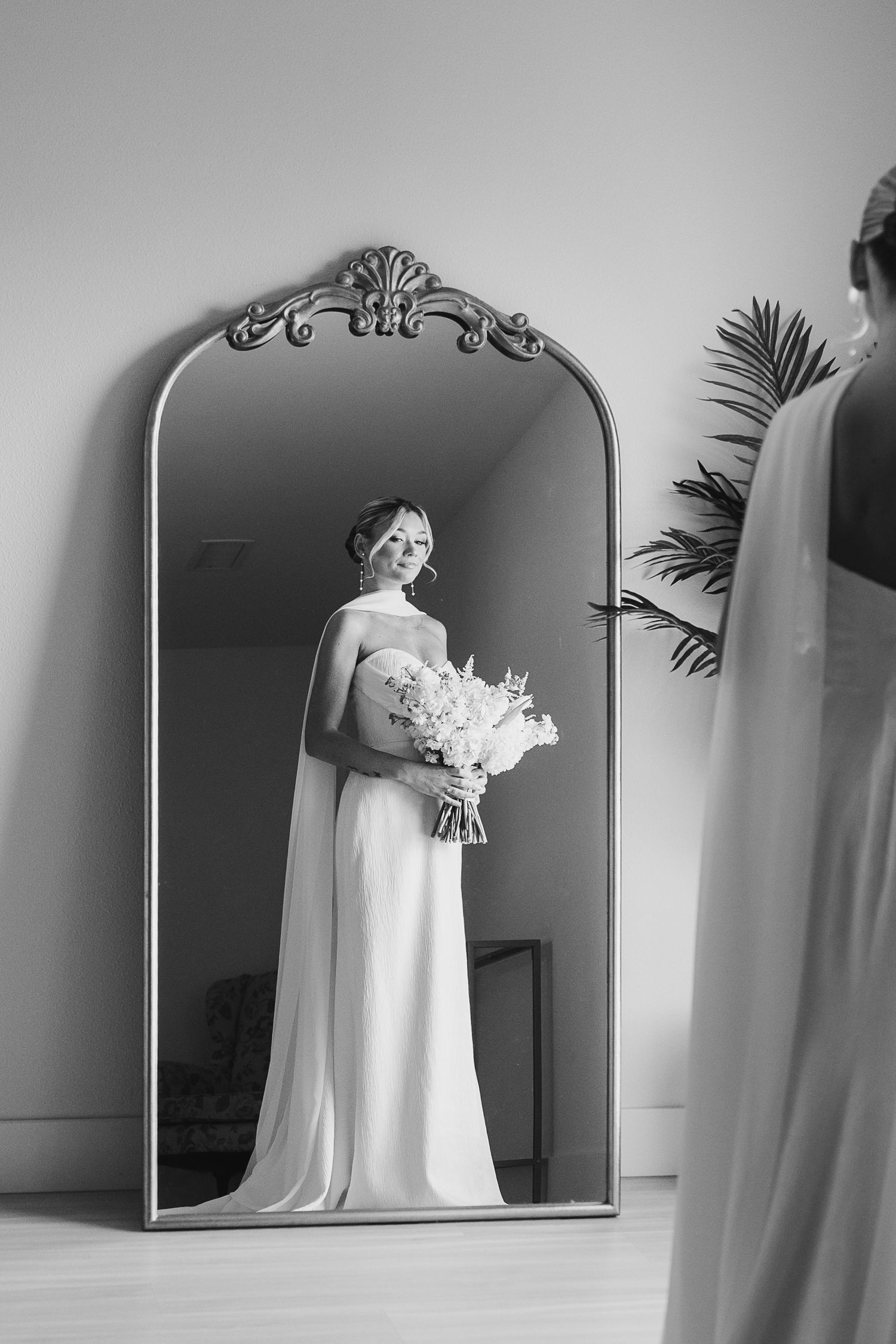 A black and white wedding photo series showing reflections of a bridal figure in arched mirrors.
