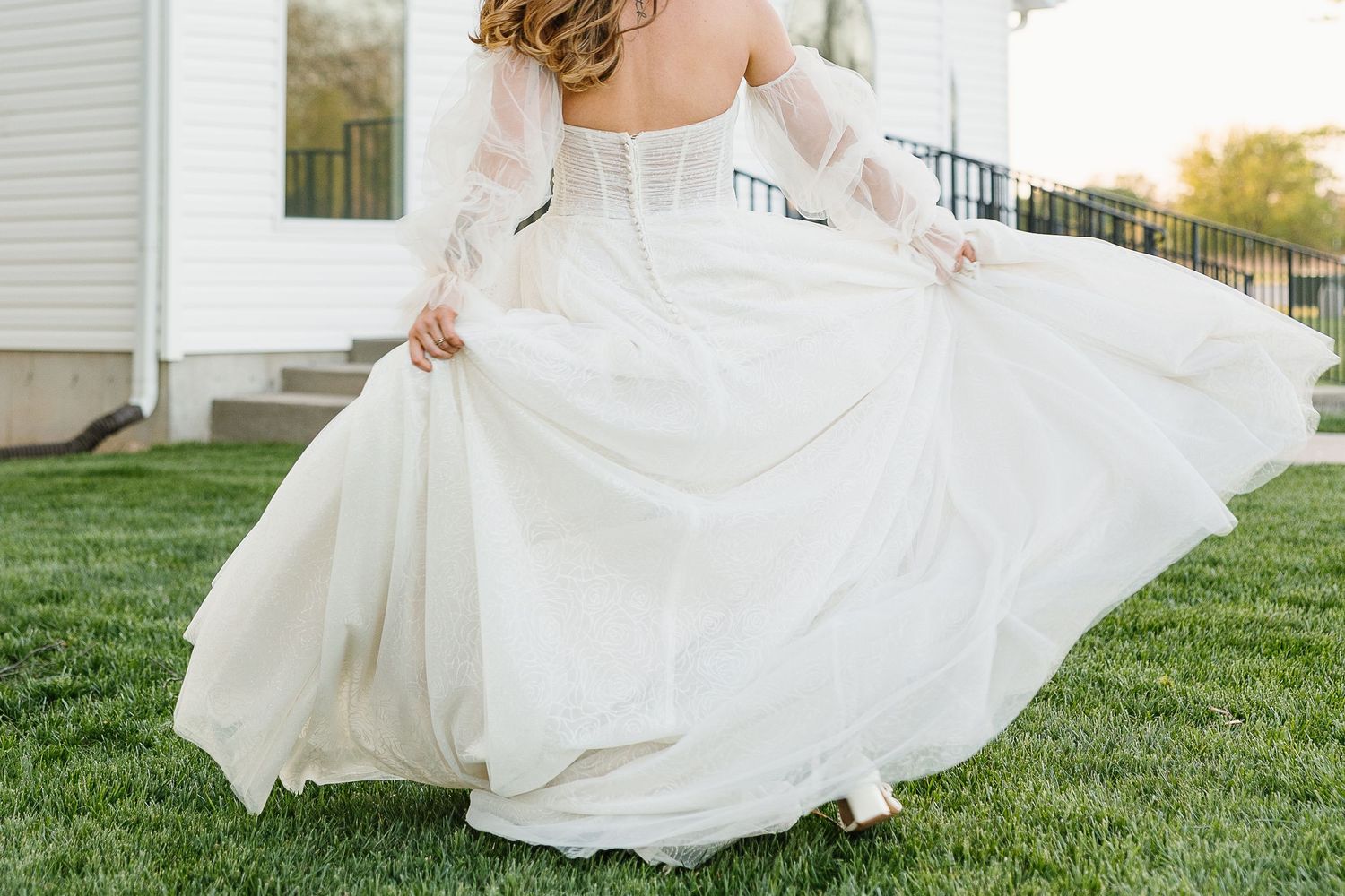 A flowing white wedding dress swirls gracefully in a series of photos taken outdoors against a sunny lawn.