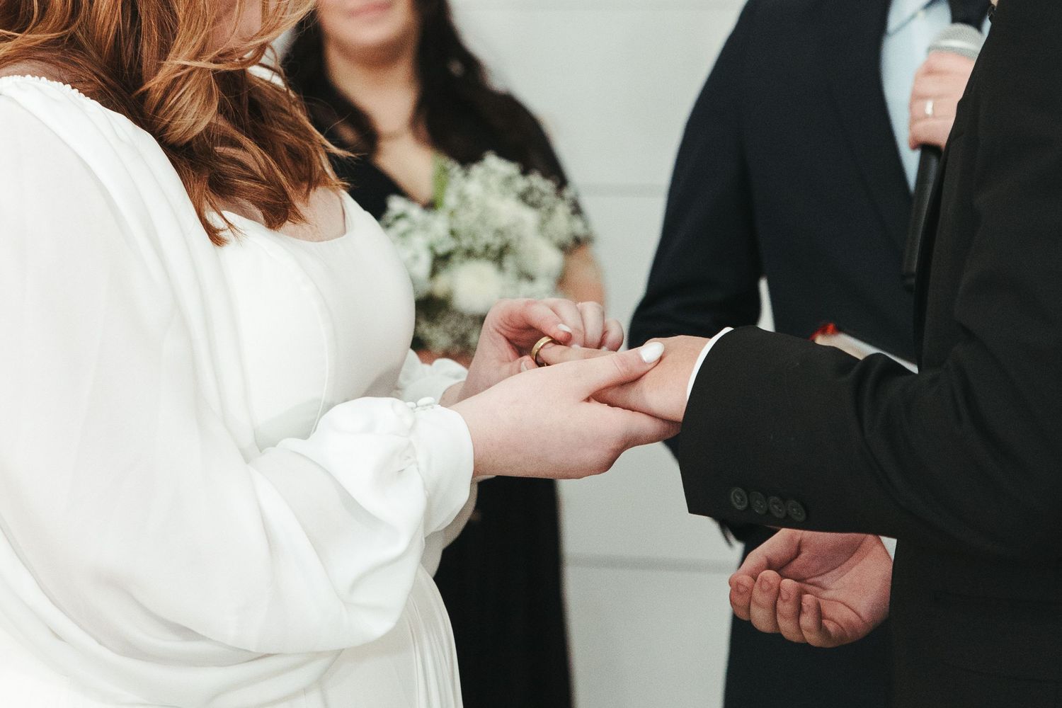 Close-up shot of wedding rings being exchanged during a traditional ceremony.