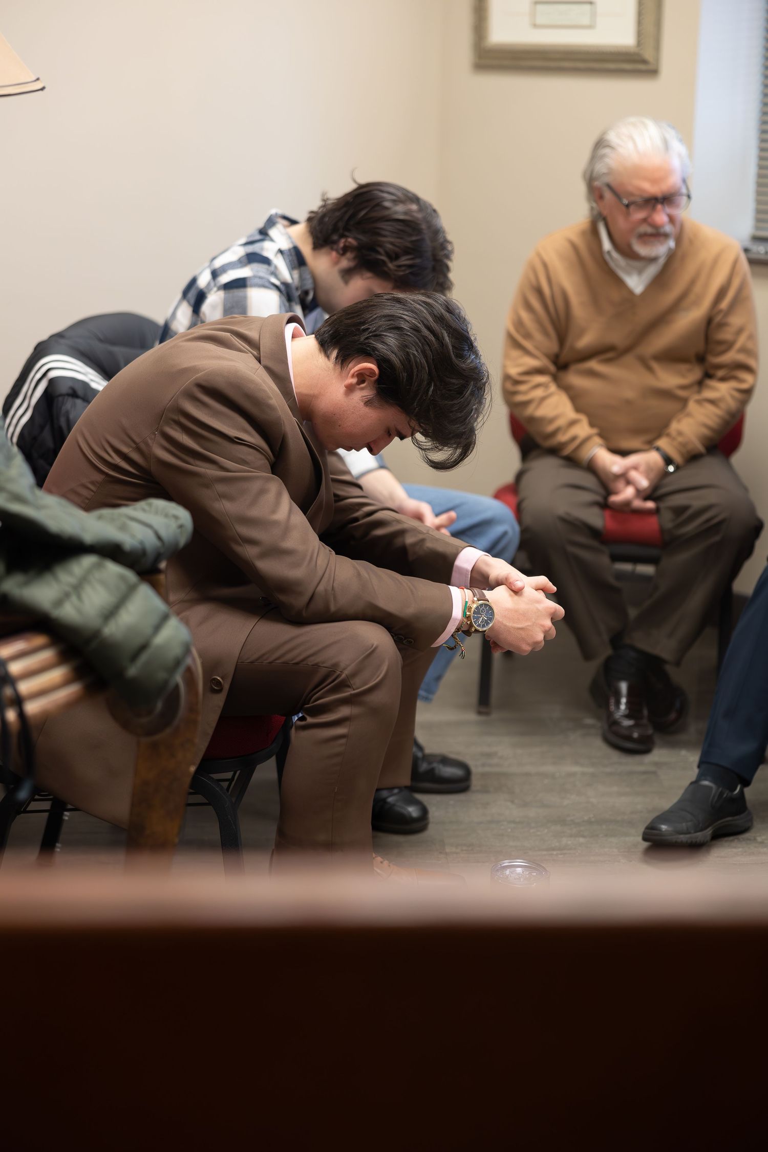 People seated in a small meeting room with a casual, contemplative atmosphere.