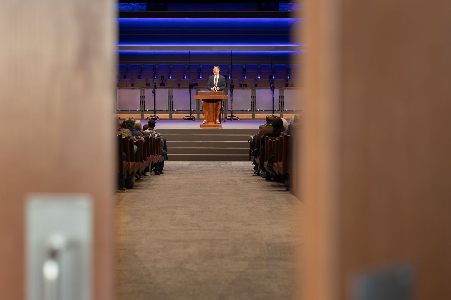 View through doorway of church sanctuary with podium on elevated platform.
