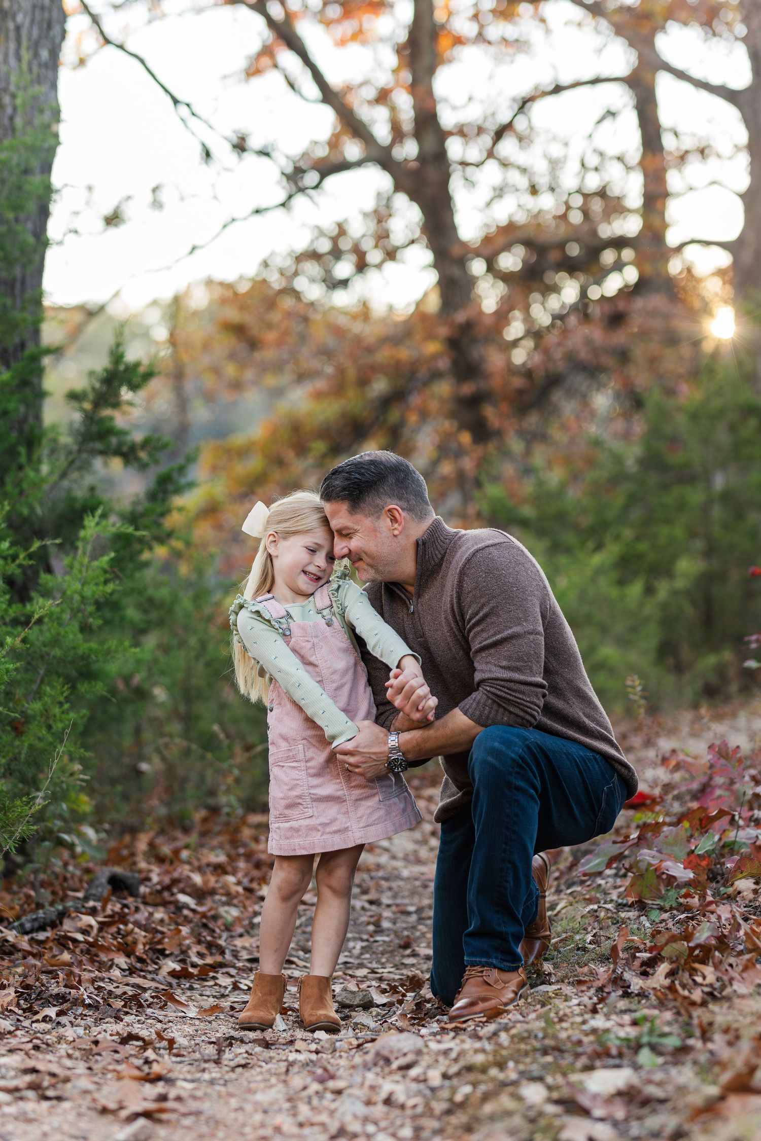 Sweet moment between adult and child on fall trail surrounded by autumn leaves.