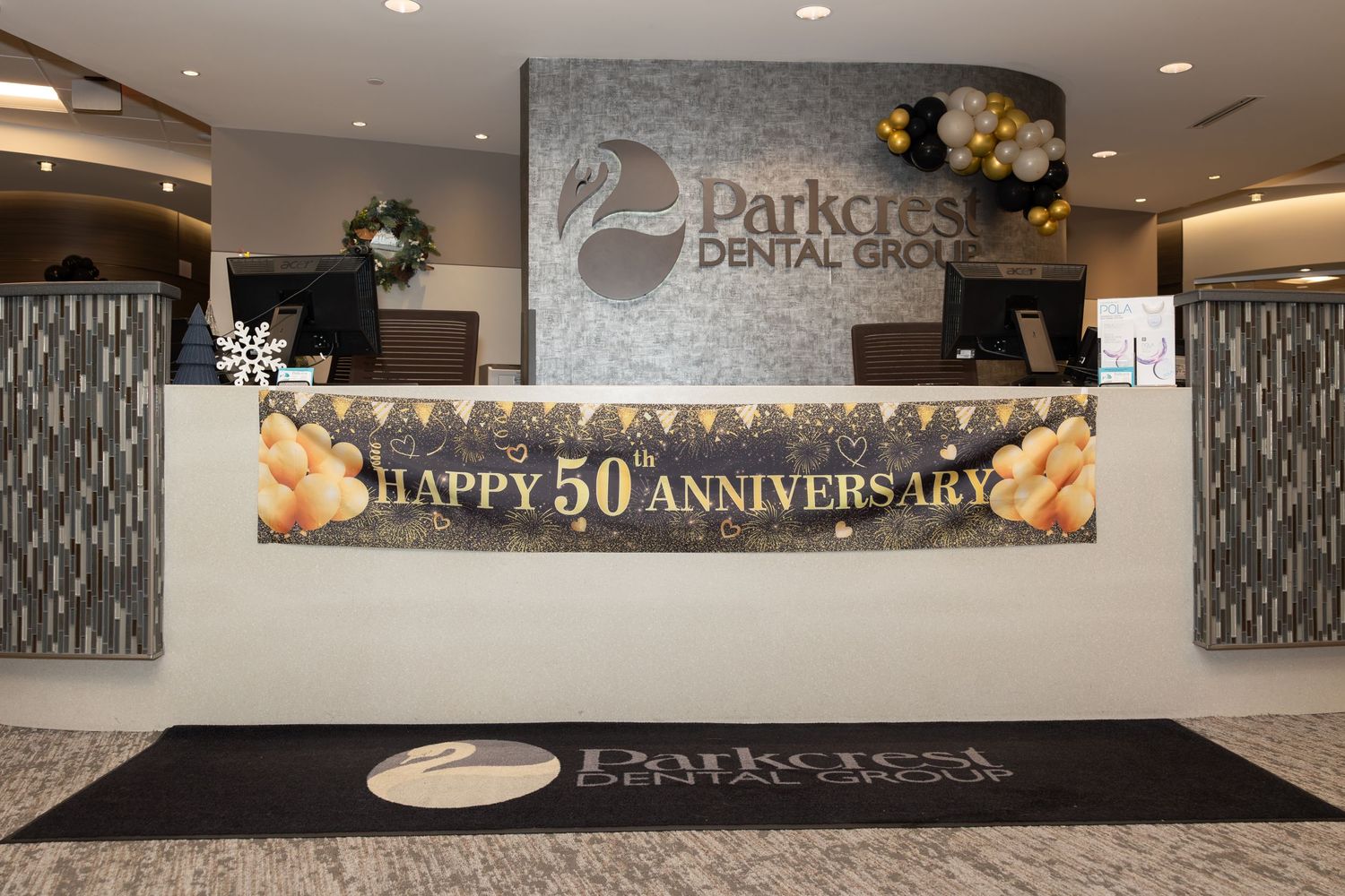 Reception area decorated with Happy 50th Anniversary banner and branded floor mat.