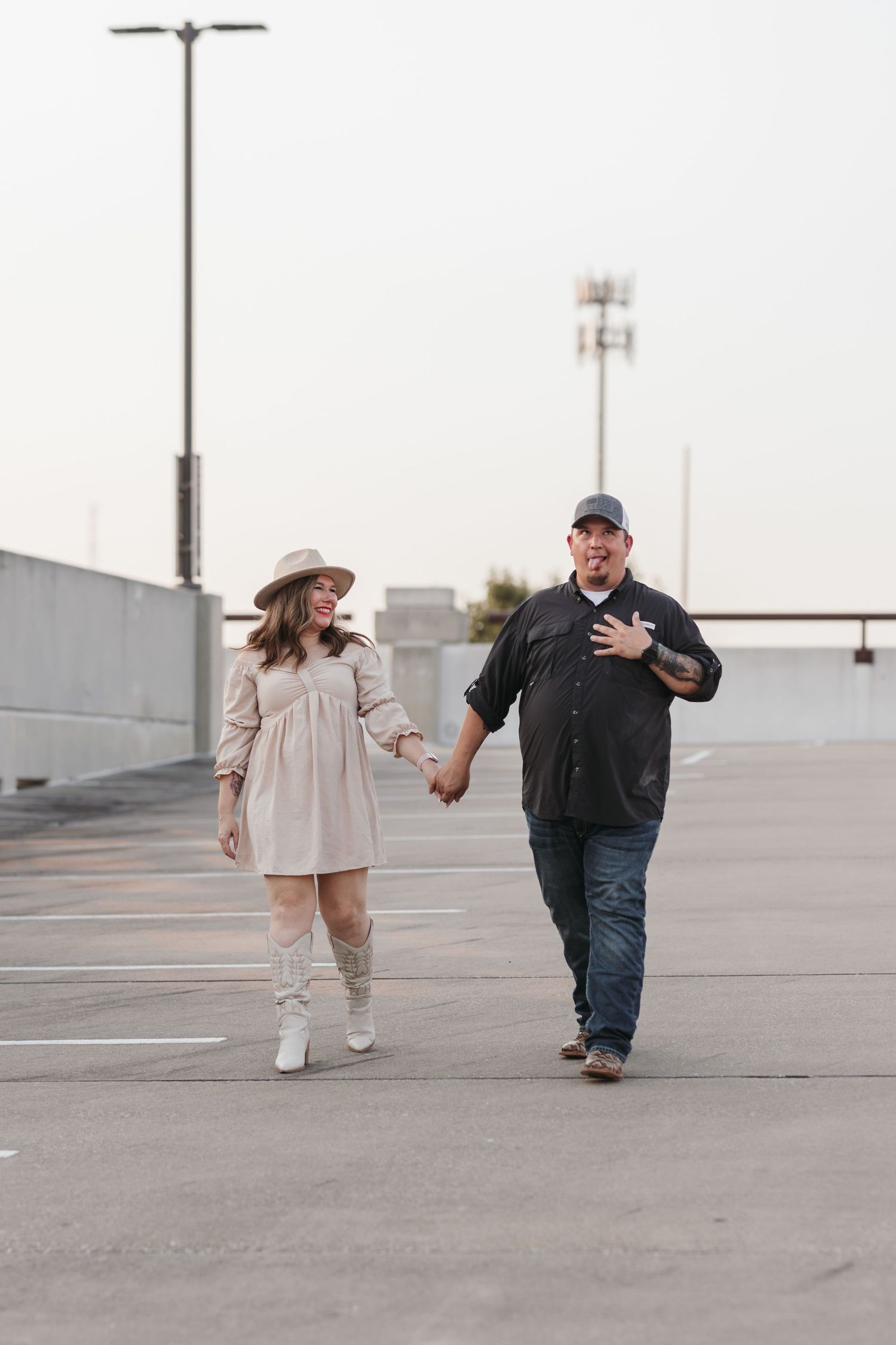 A couple strolling together on a parking structure rooftop.