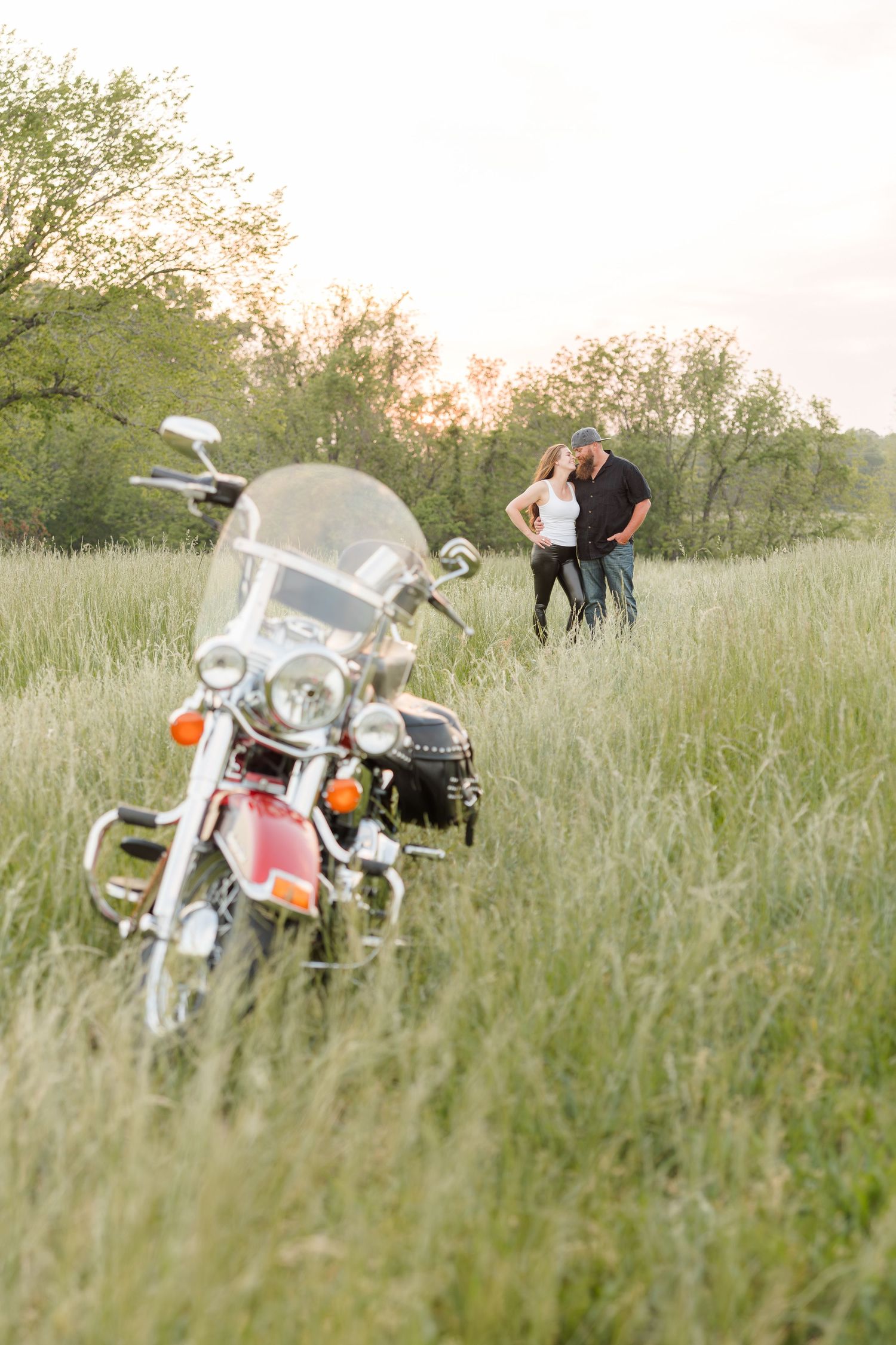 A sequence of photos showing a motorcycle parked in tall grass at sunset while a couple shares a romantic moment.