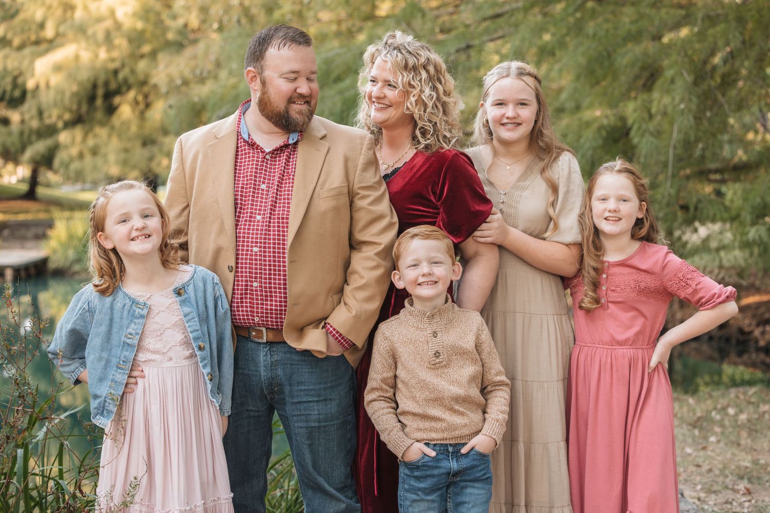 Casual family portrait outdoors with coordinated fall clothing.